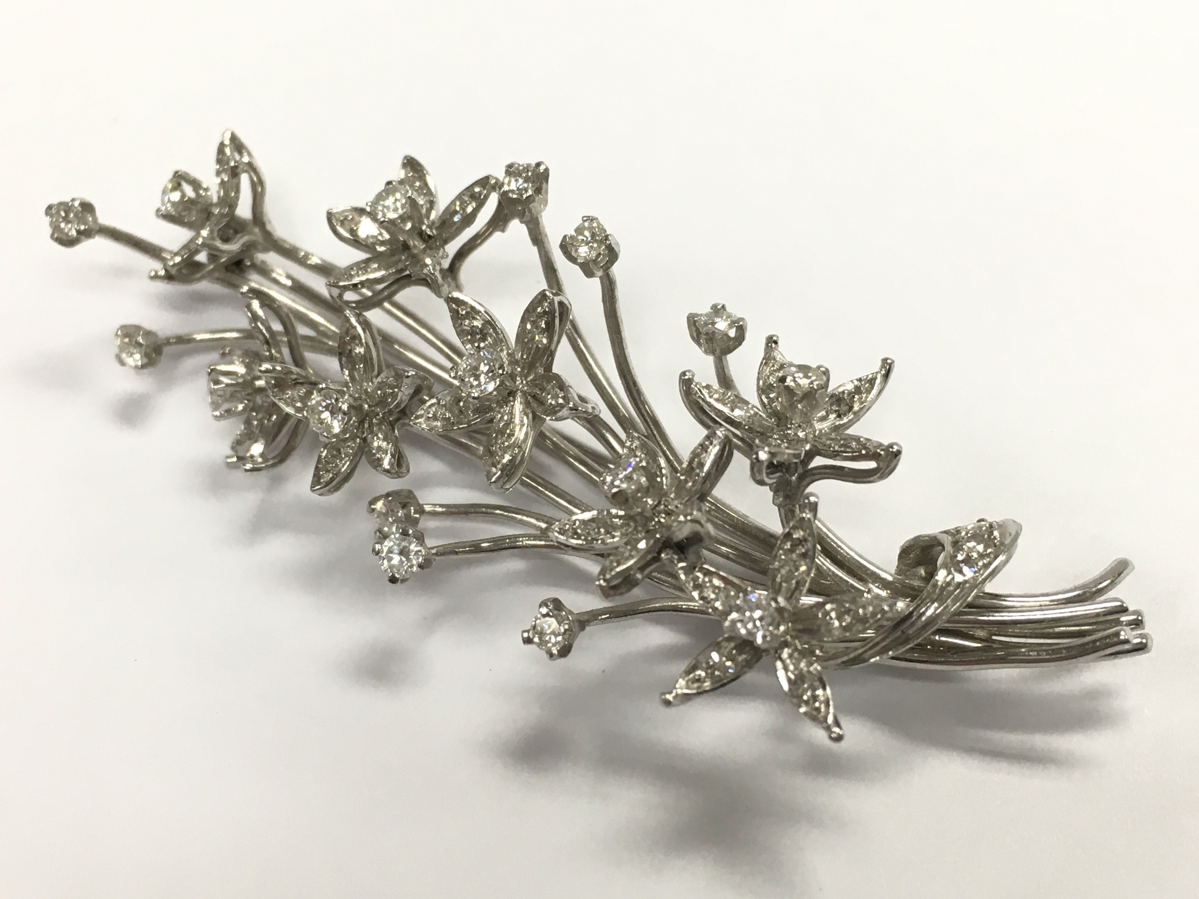 An 18ct white gold spray diamond brooch, total weight 16.2g postage category A