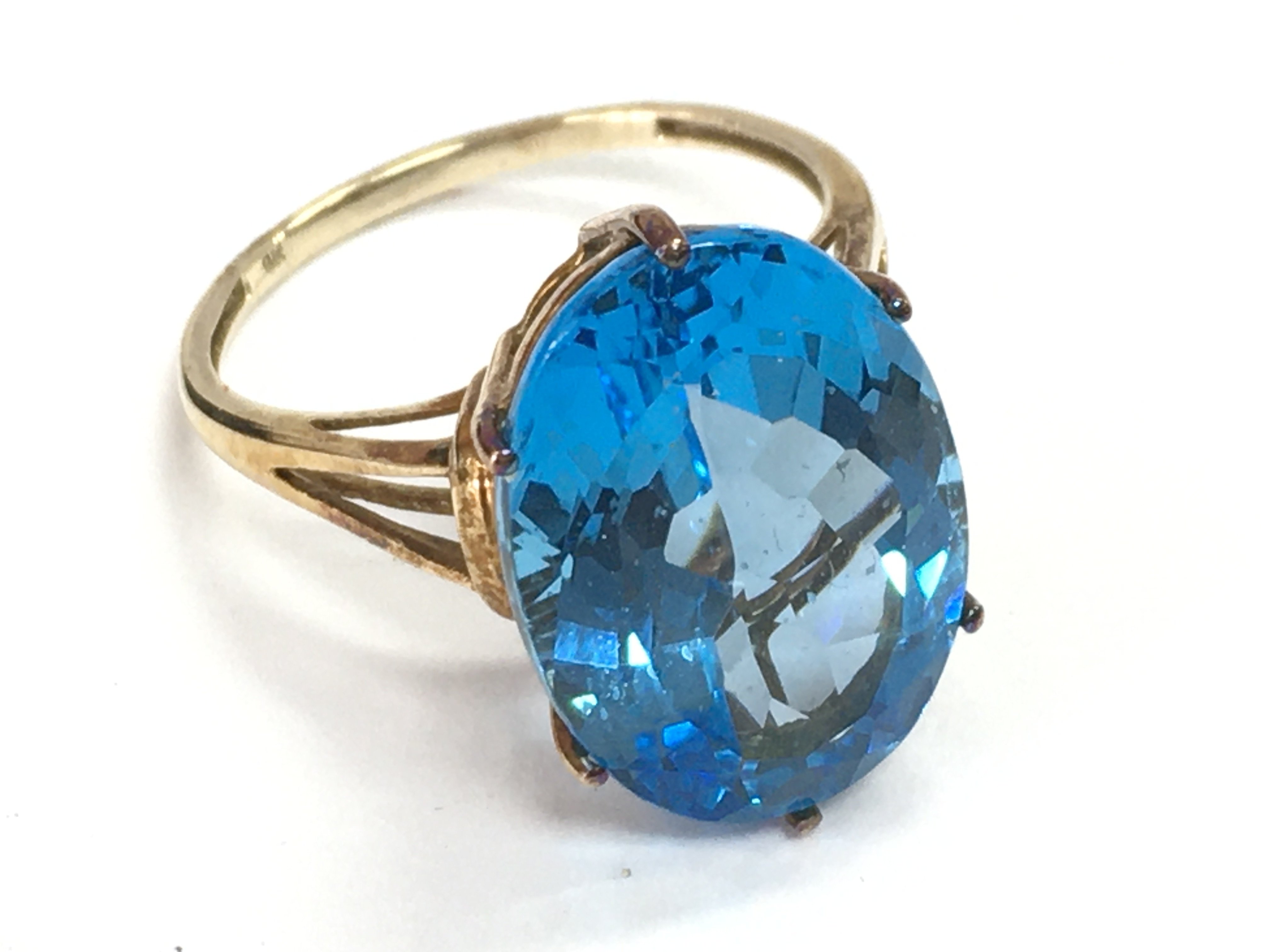 A 9 carat gold ring set with a large blue gemstone , 5.3g total weight. Size S. Postage category A