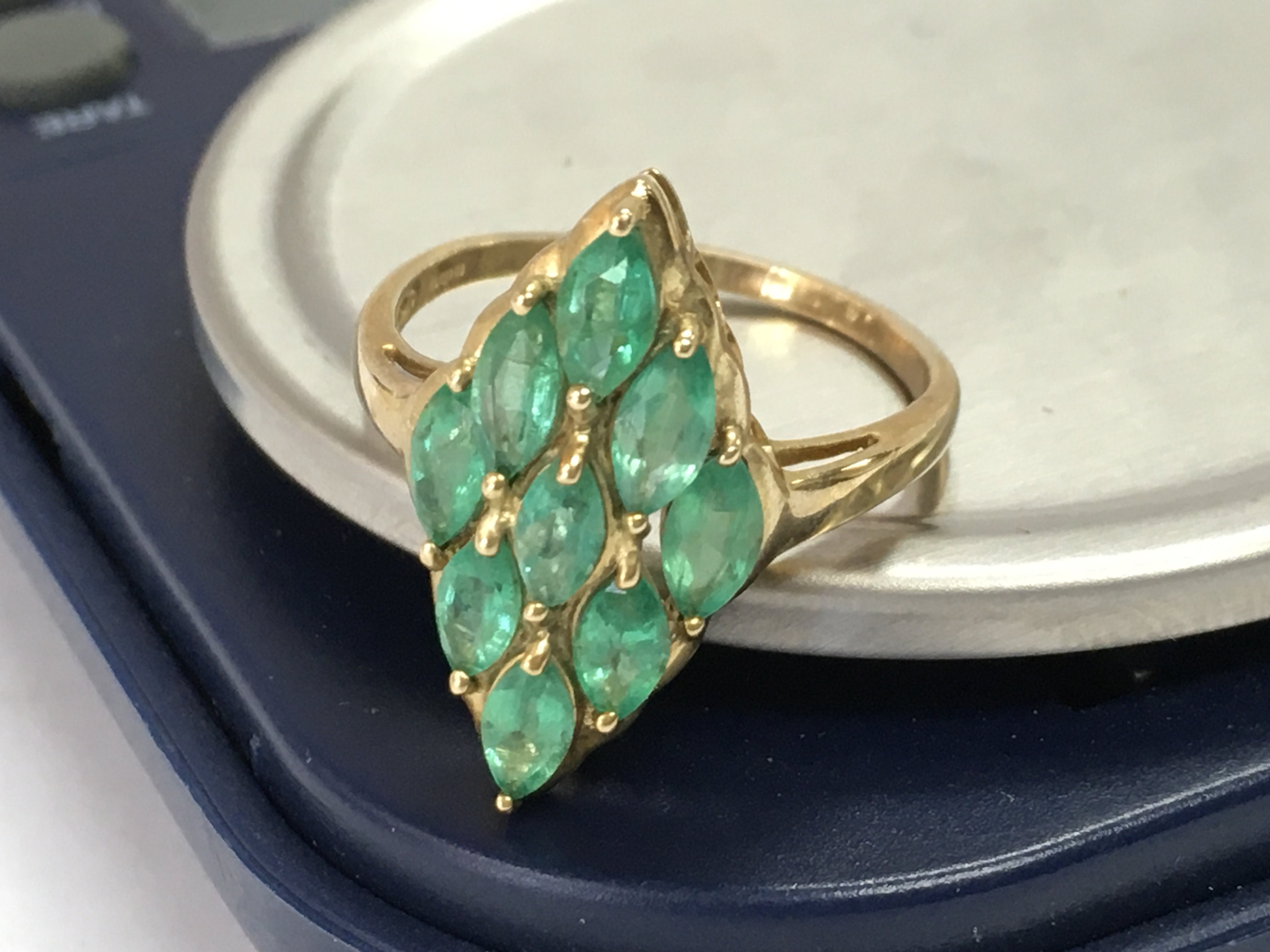 A 9ct gold art deco style ring set with green gemstones , size Q. postage category A