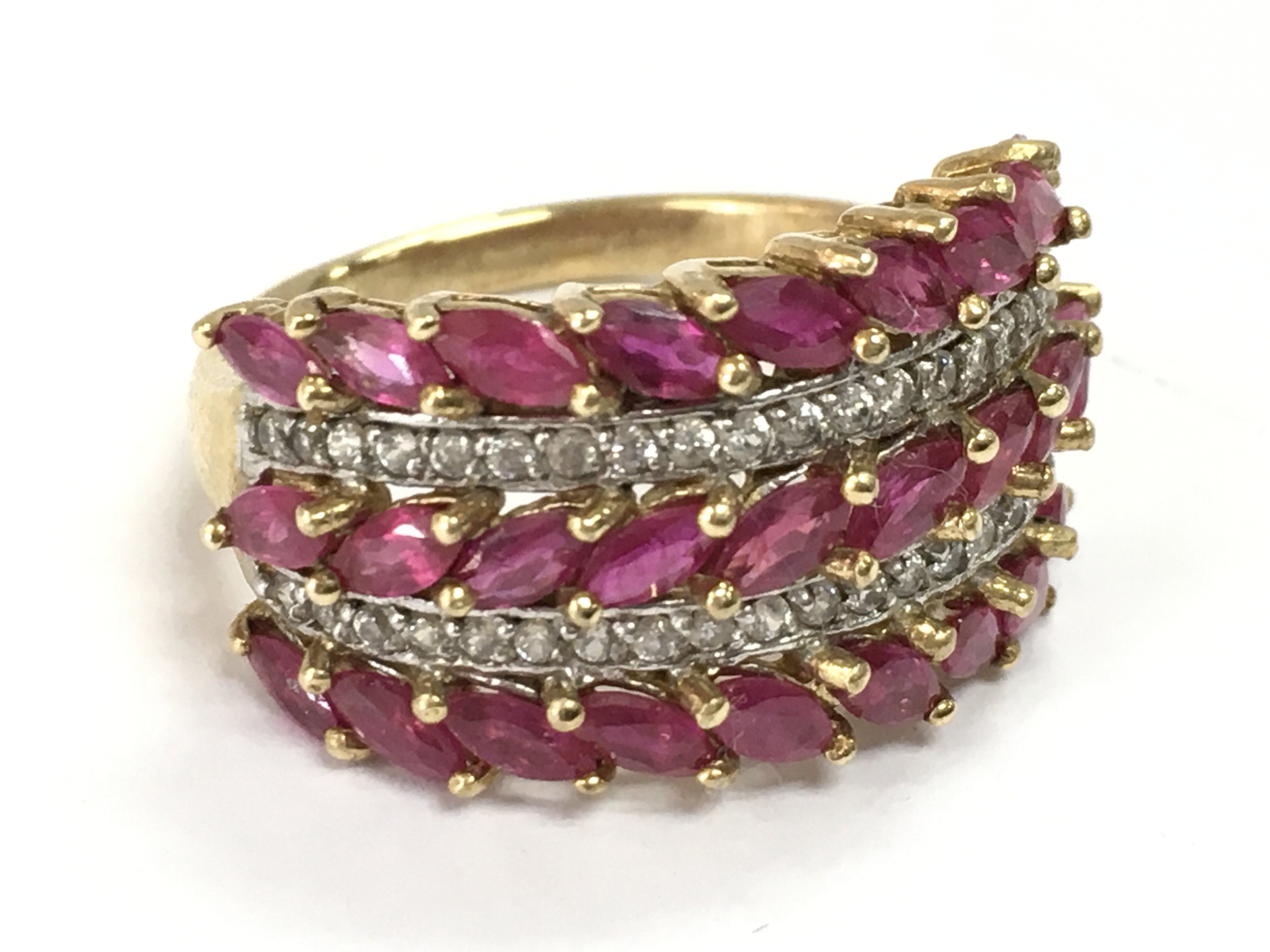 A 9 carat gold ruby and diamond set three row band ring . 5g total weight. Postage category A