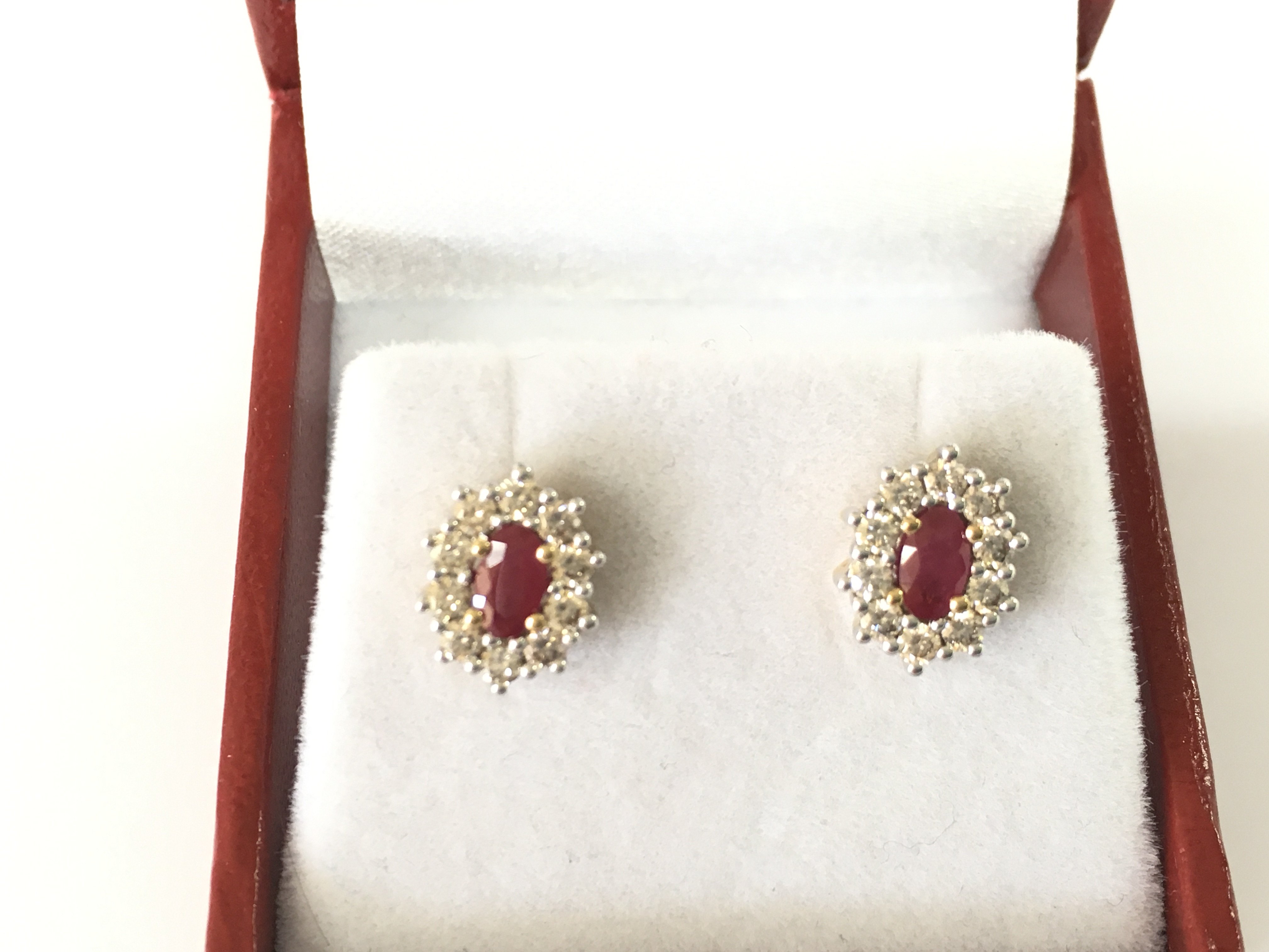 A pair of 9ct yellow gold oval ruby and diamond cluster studs. Rubies 0.48ct and diamonds 0.53ct. Postage B
