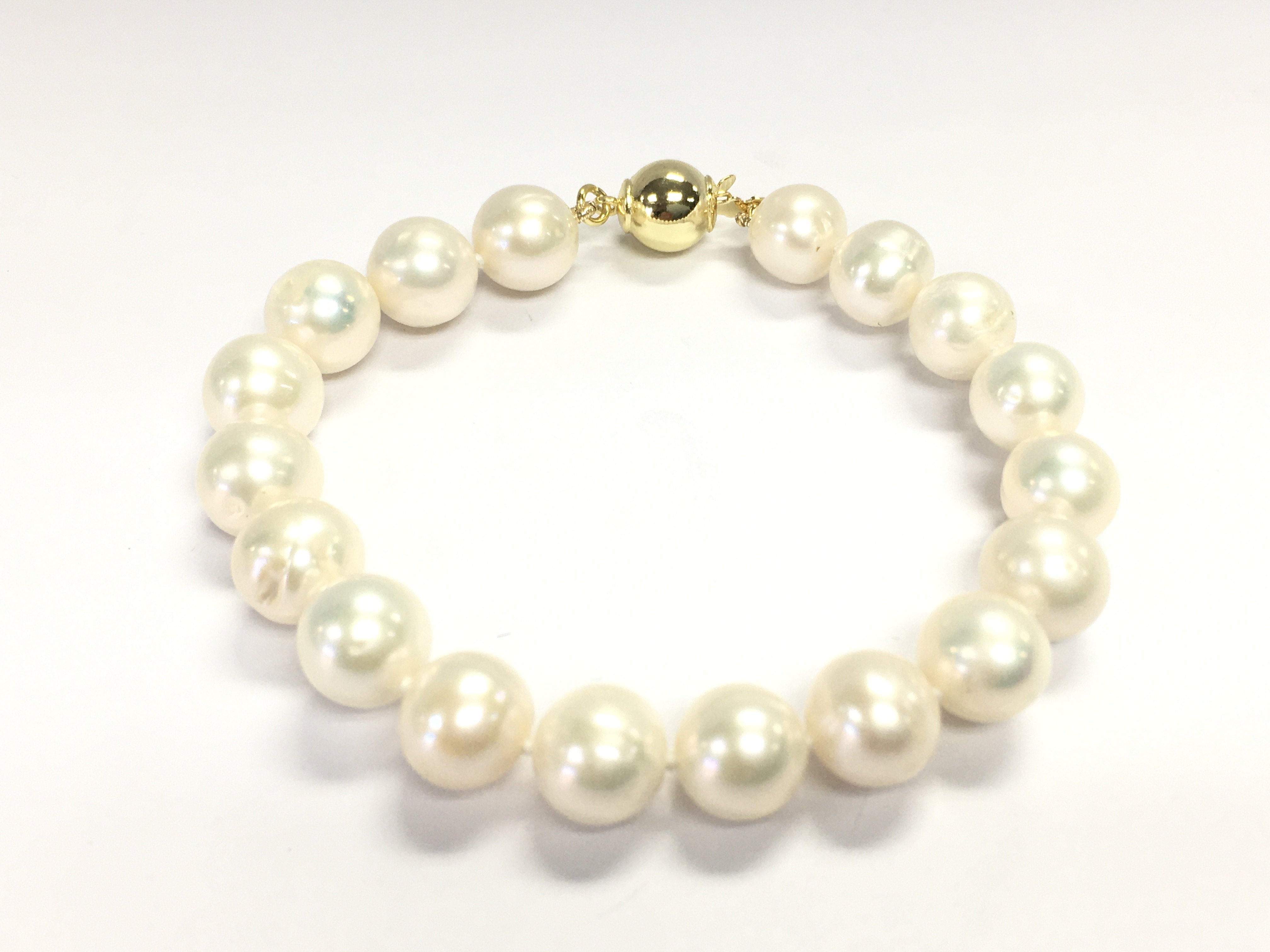 A white cultured Pearl bracelet with gold plated silver ball clasp. Postage B
