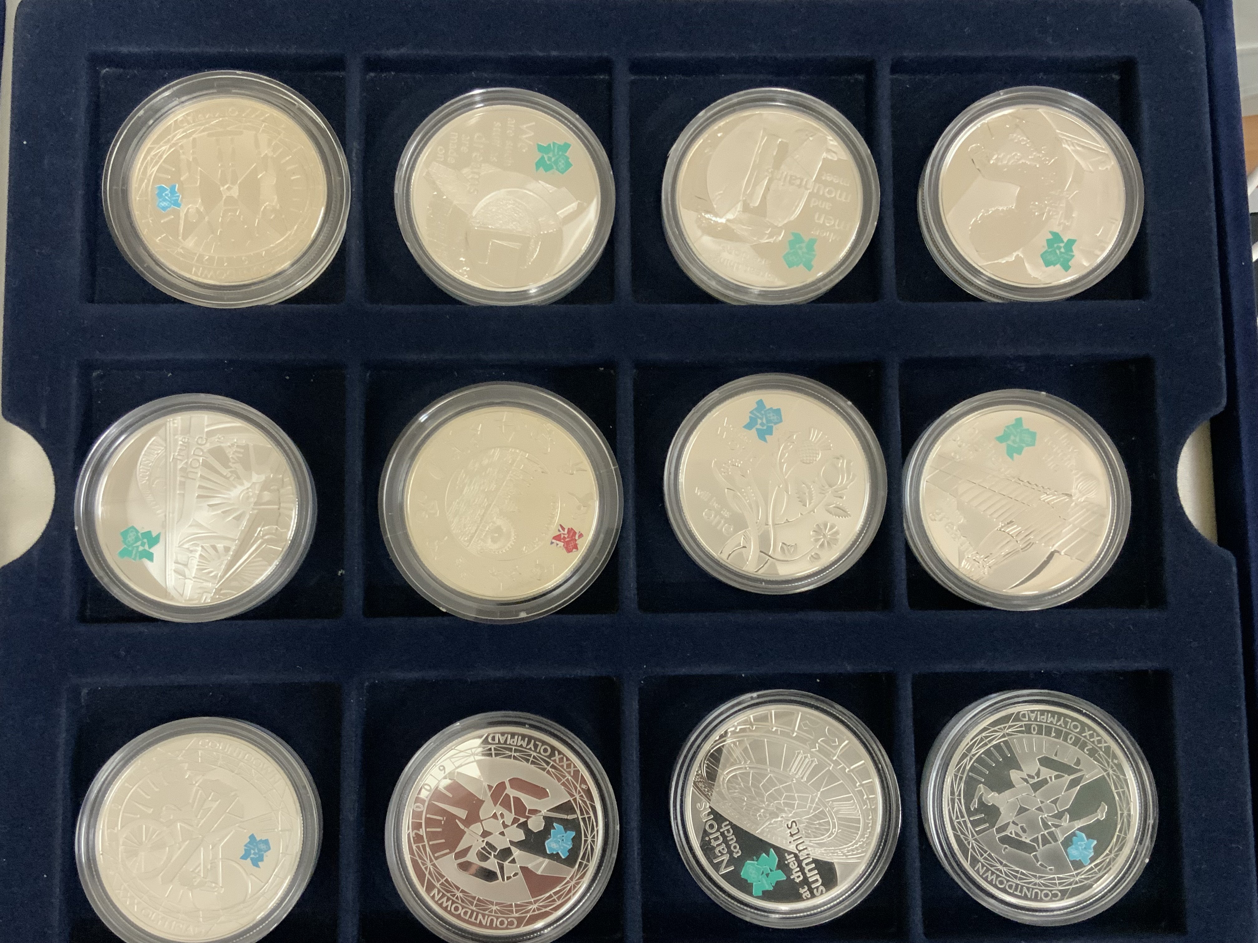 A good collection of sterling silver commemorative coins to include a a London 2012 Silver 50p sports collection and Royal Mint 2012 &#20132662755 silver proof collection, together with 2 Westminster numismatic philatelic silver coin covers, QE2 Silver &#20132662755 proof coin (43 coins).