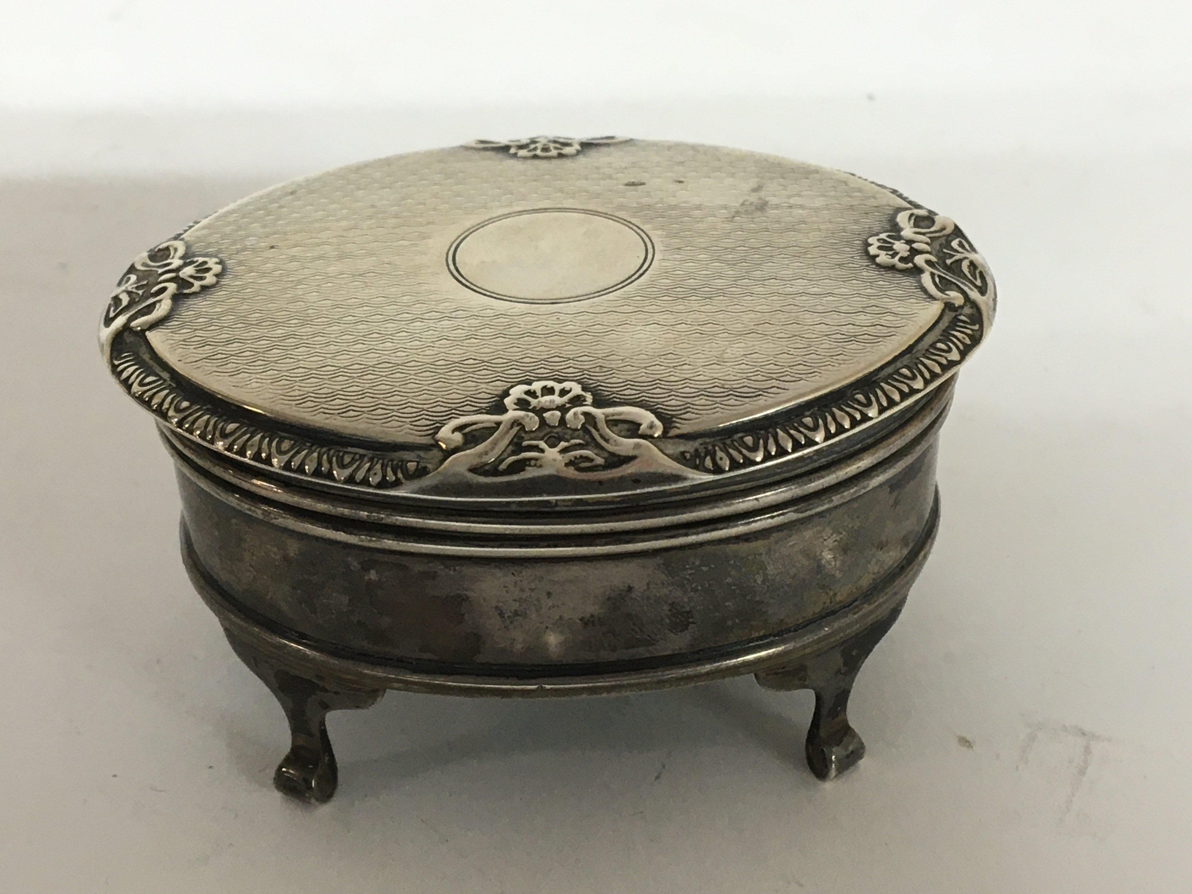 A silver oval shaped ring box 7.5cm diameter with a lined interior. Birmingham hallmarks.