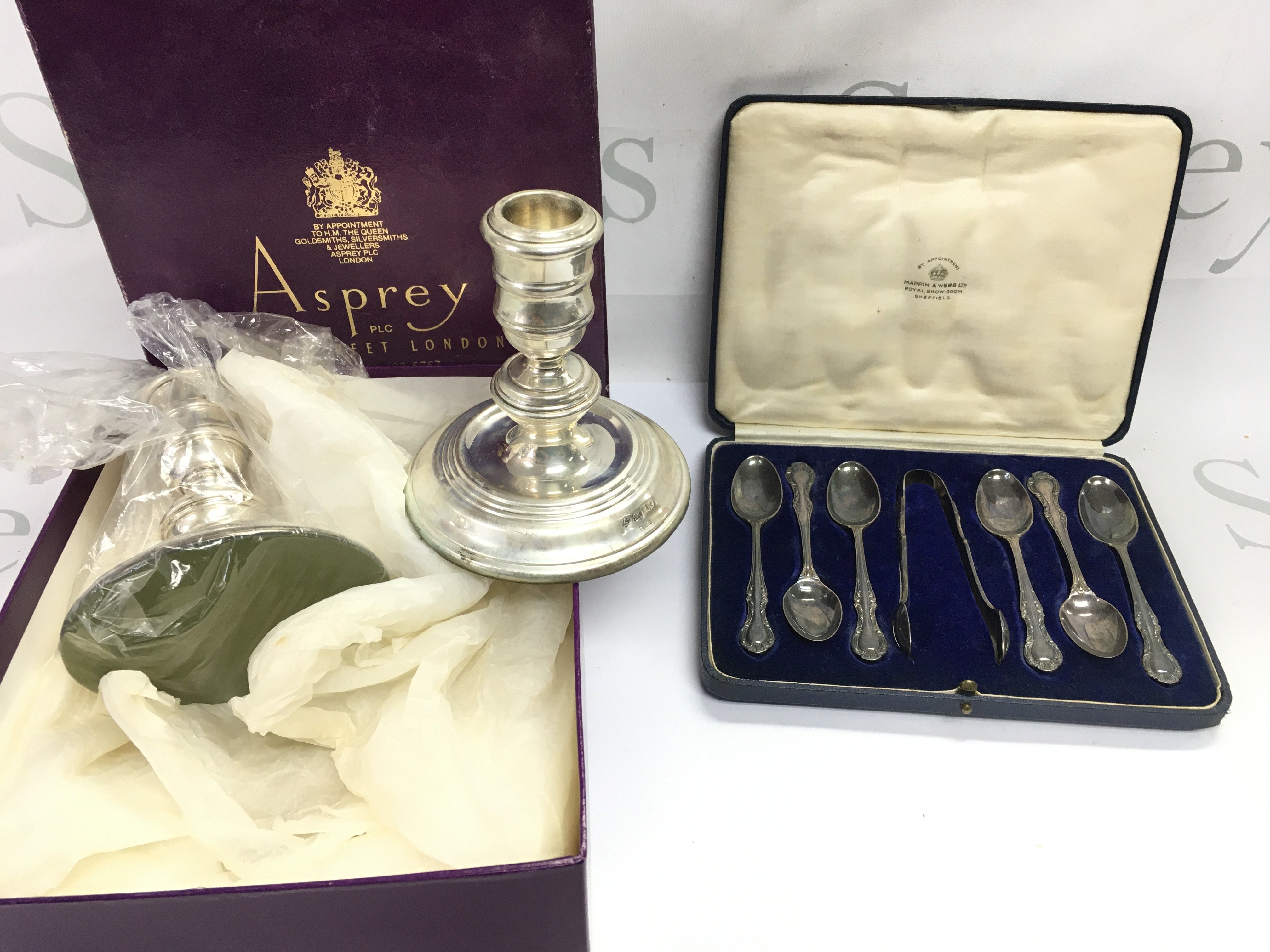 A pair of boxed Asprey hallmarked candlesticks and a cased set of Mappin and Webb silver spoons. Postage B