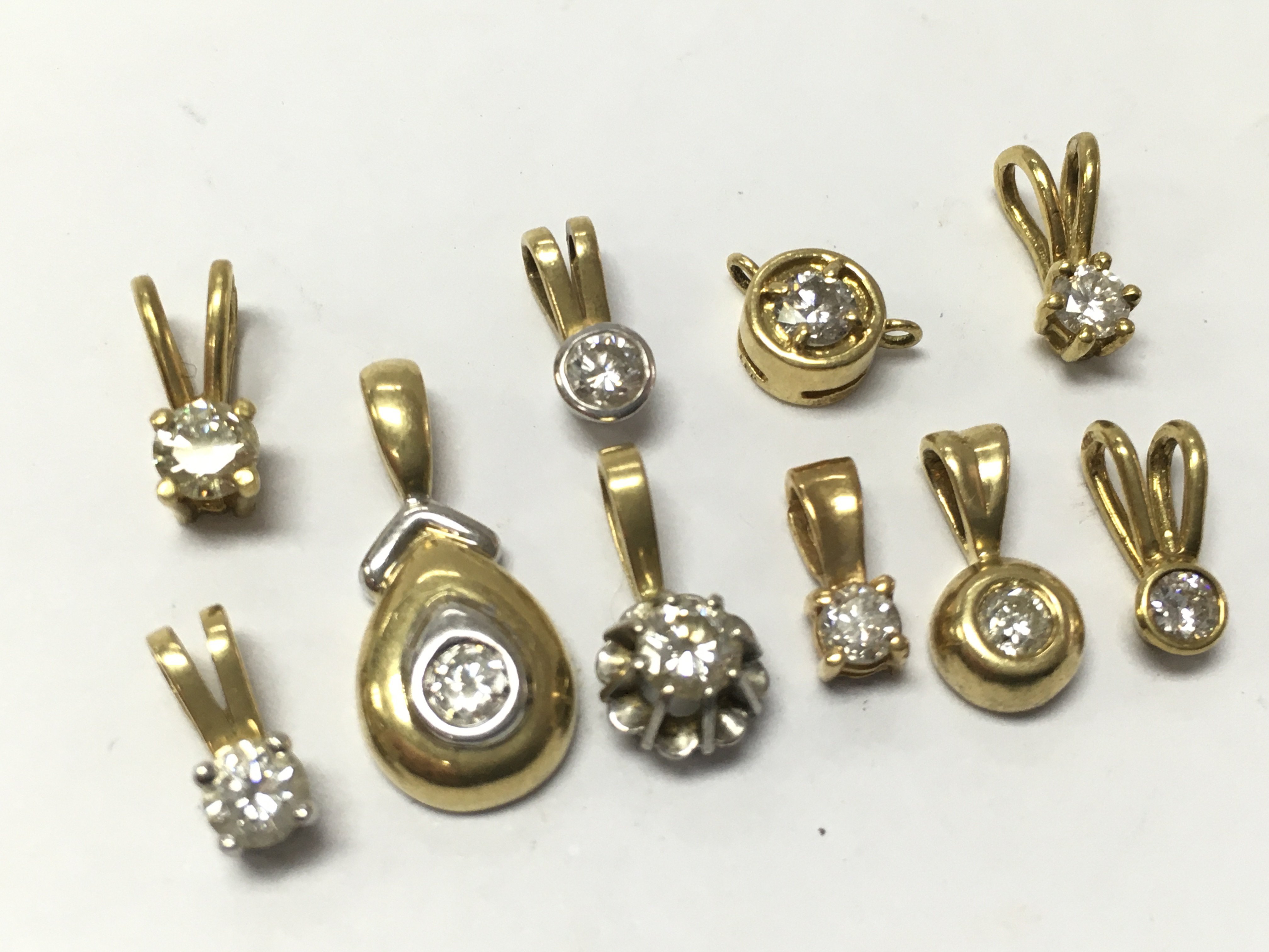 A collection of 18ct yellow and white gold pendants set with diamonds , 7.45g . Postage category A