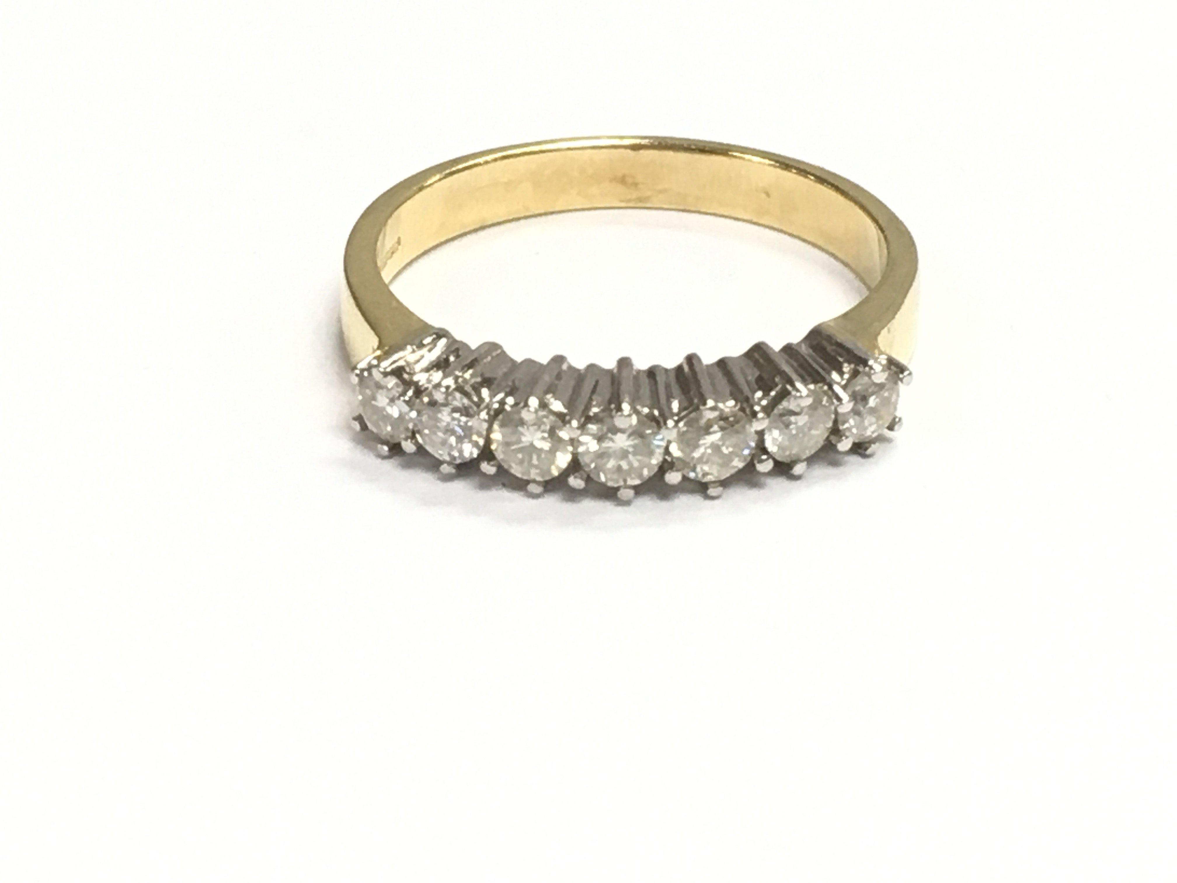 An 18ct gold diamond seven stone ring. Size M 1/2 and 3.71g Postage A