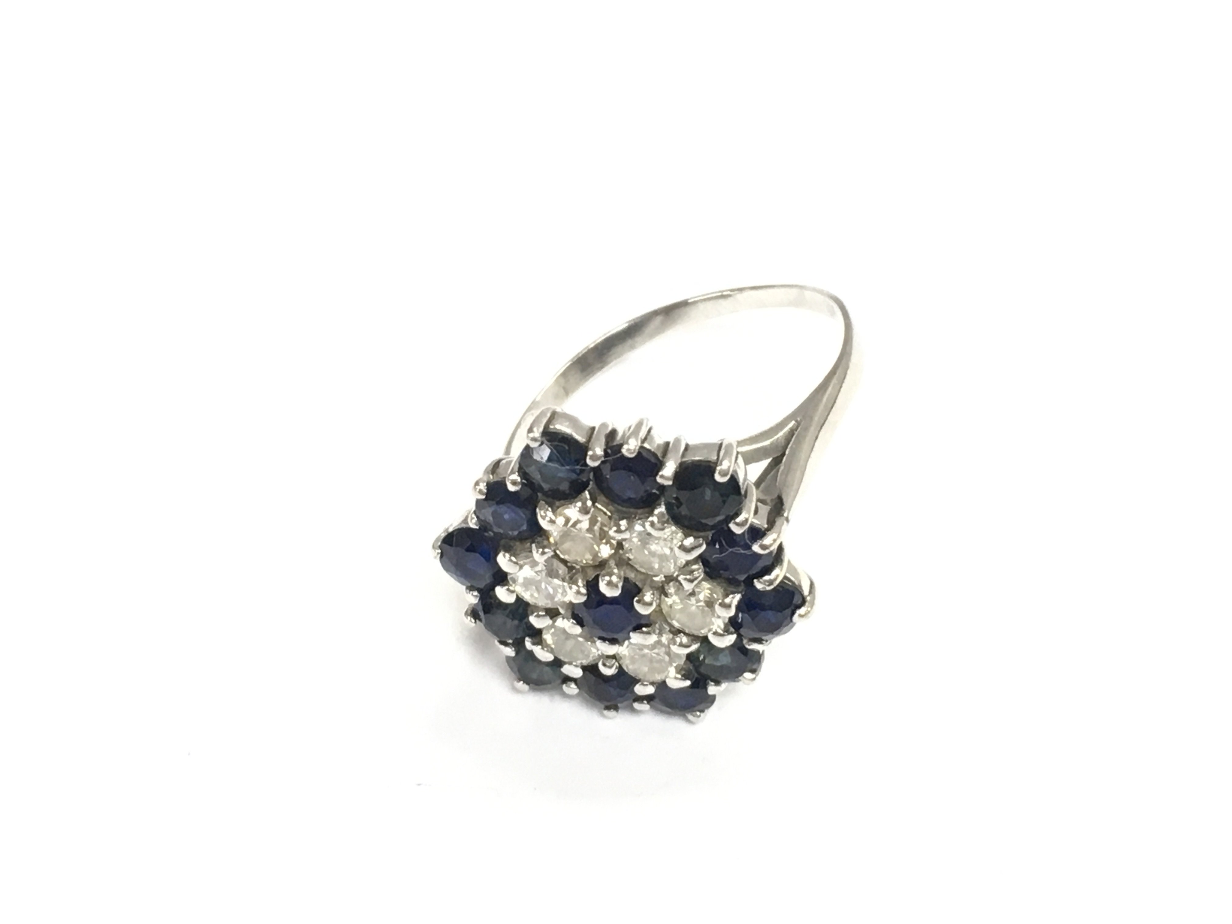 An unmarked white gold sapphire and diamond cluster ring. Size O 1/2 and 5.60g Postage B