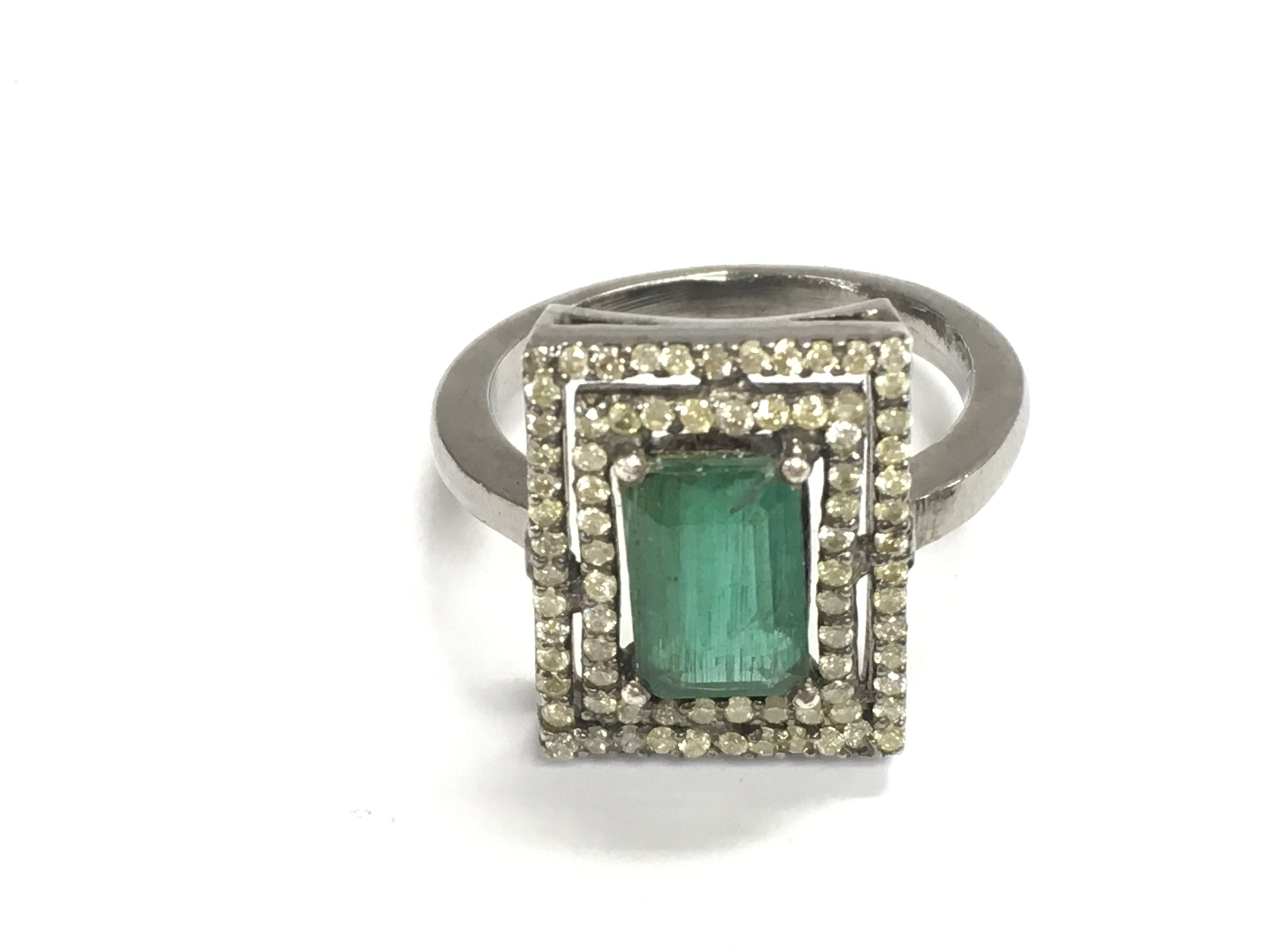 A diamond and emerald ring. Size N and 4.9g Postage B
