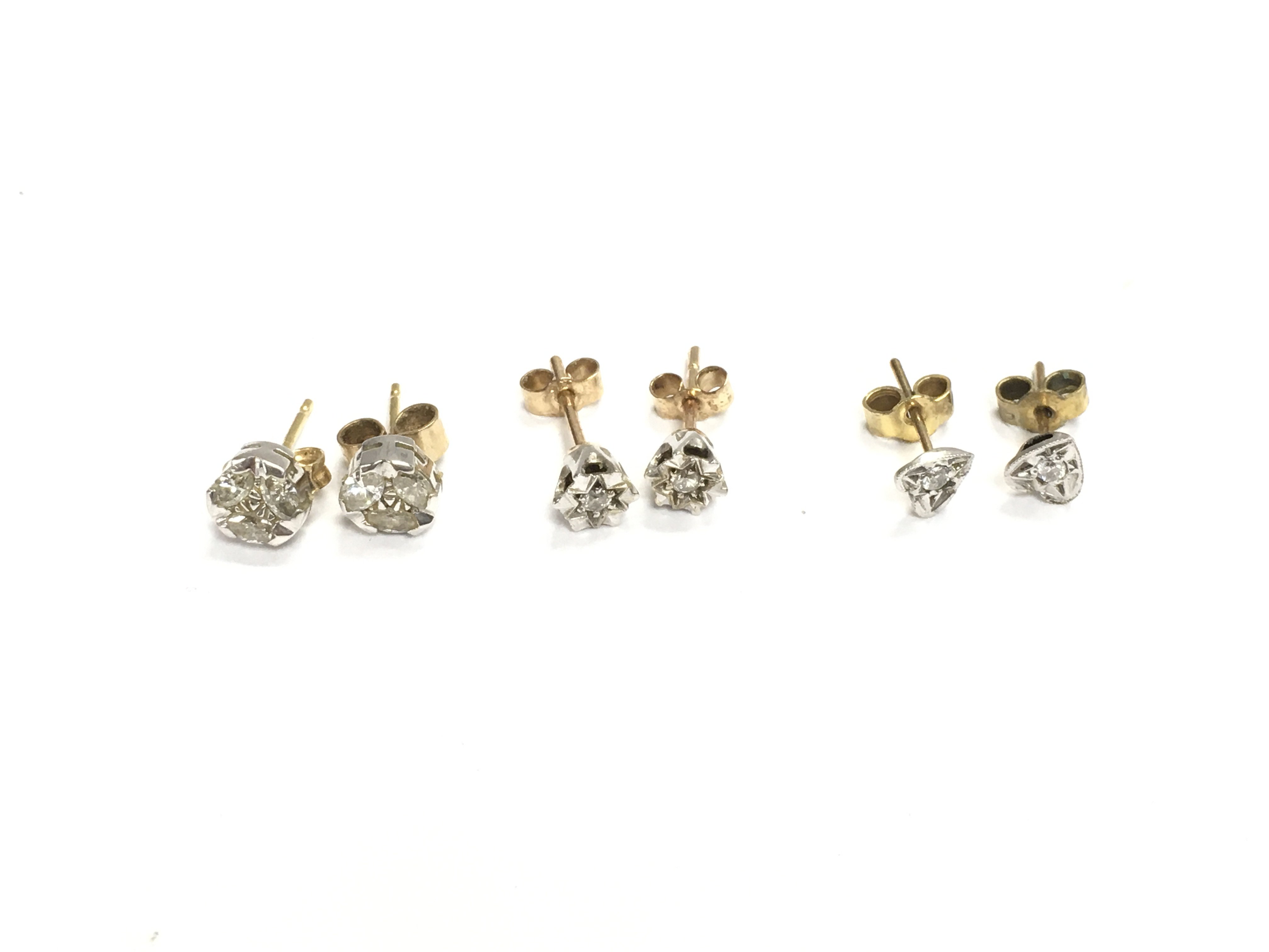 Three pairs of 9ct gold diamond stud earrings. 3.16g