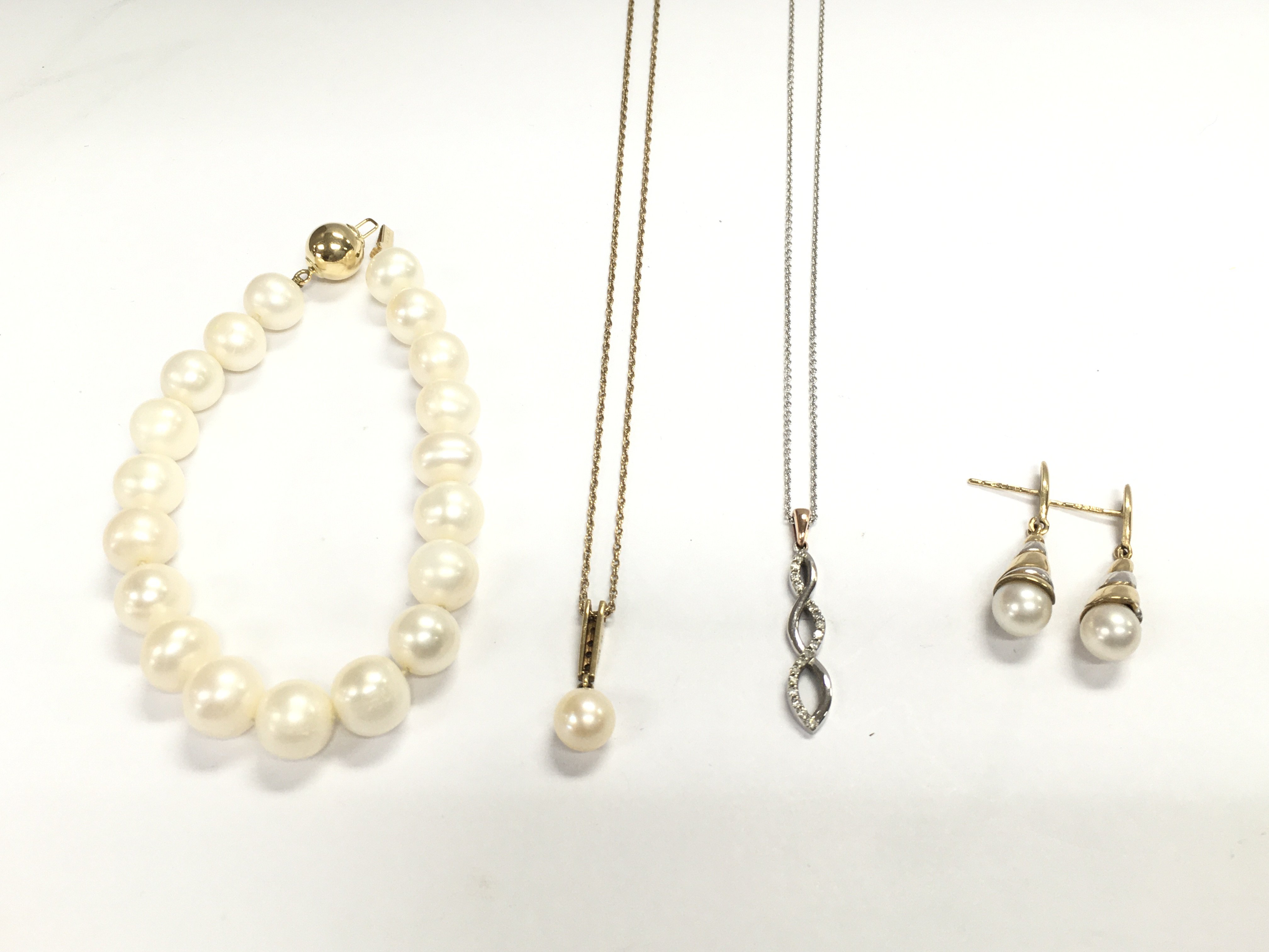 A pair of 9ct gold pearl earrings a pearl bracelet with a 14ct clasp a 9ct gold necklace with pearl pendant and an 18ct white gold chain with 9ct pendant.