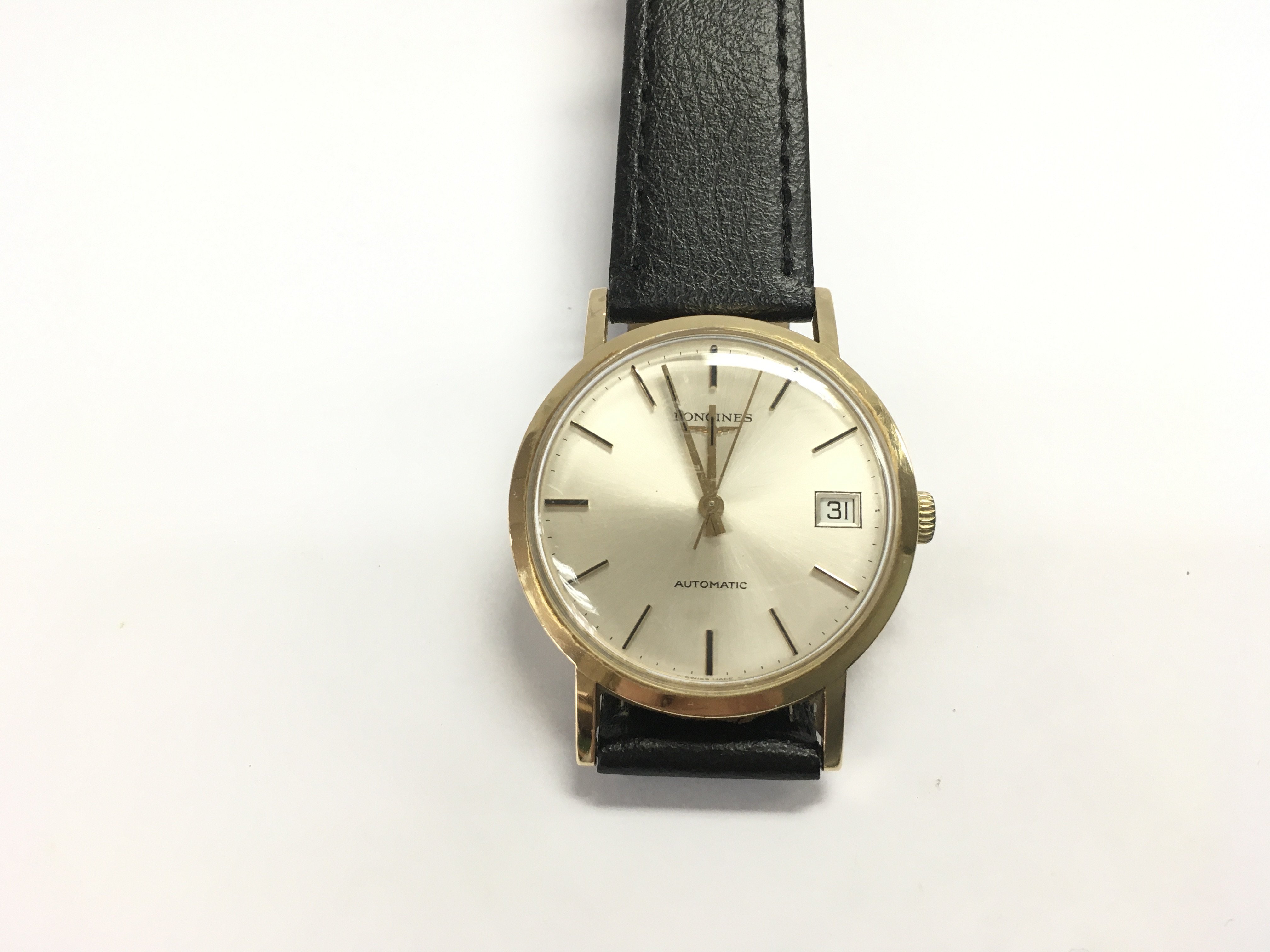 A 9ct gold cased gents Longines automatic wrist watch on black leather strap. Winds and runs. Postage B