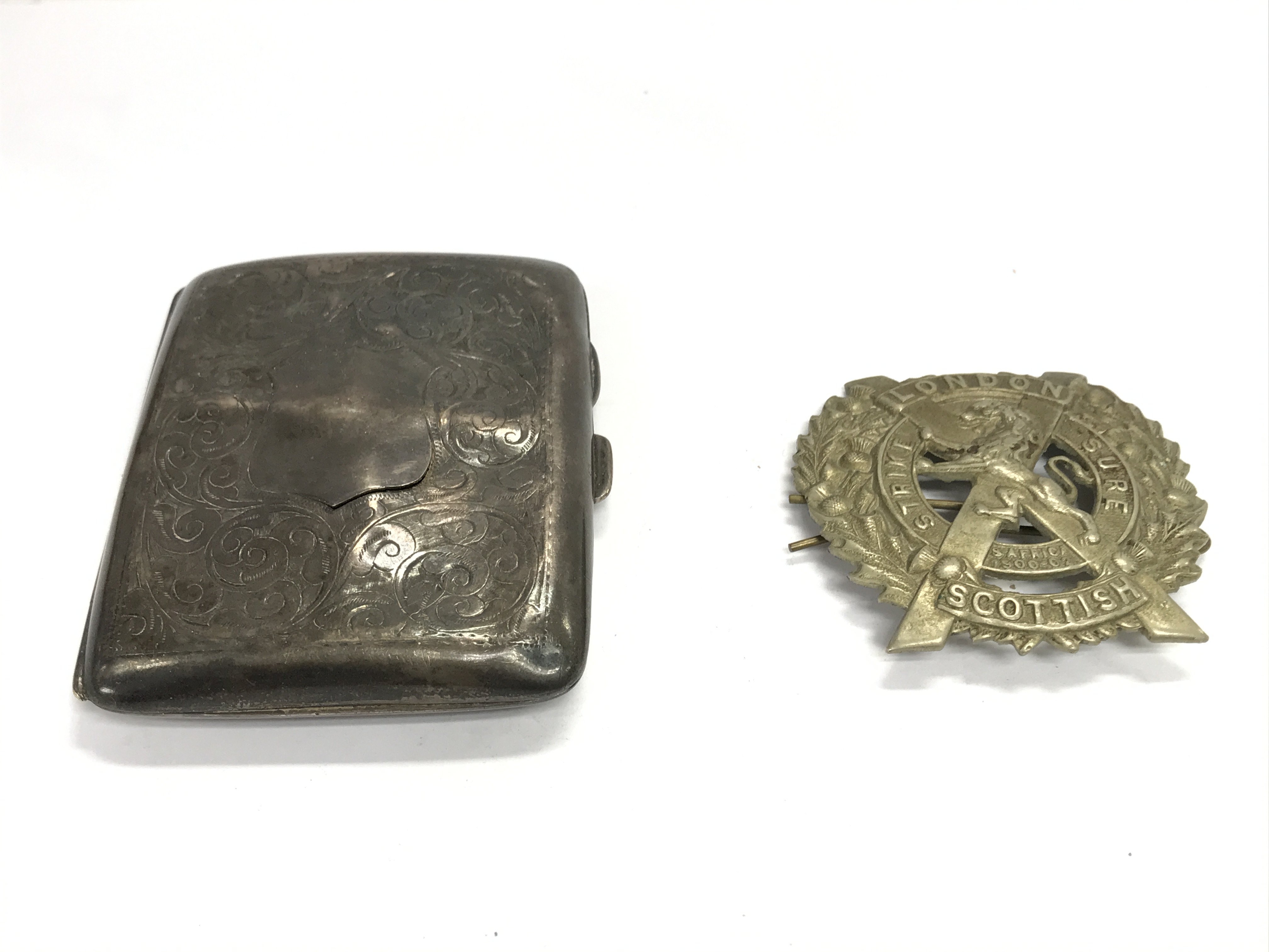 A silver cigarette case and London Scottish regiment cap badge. Postage B