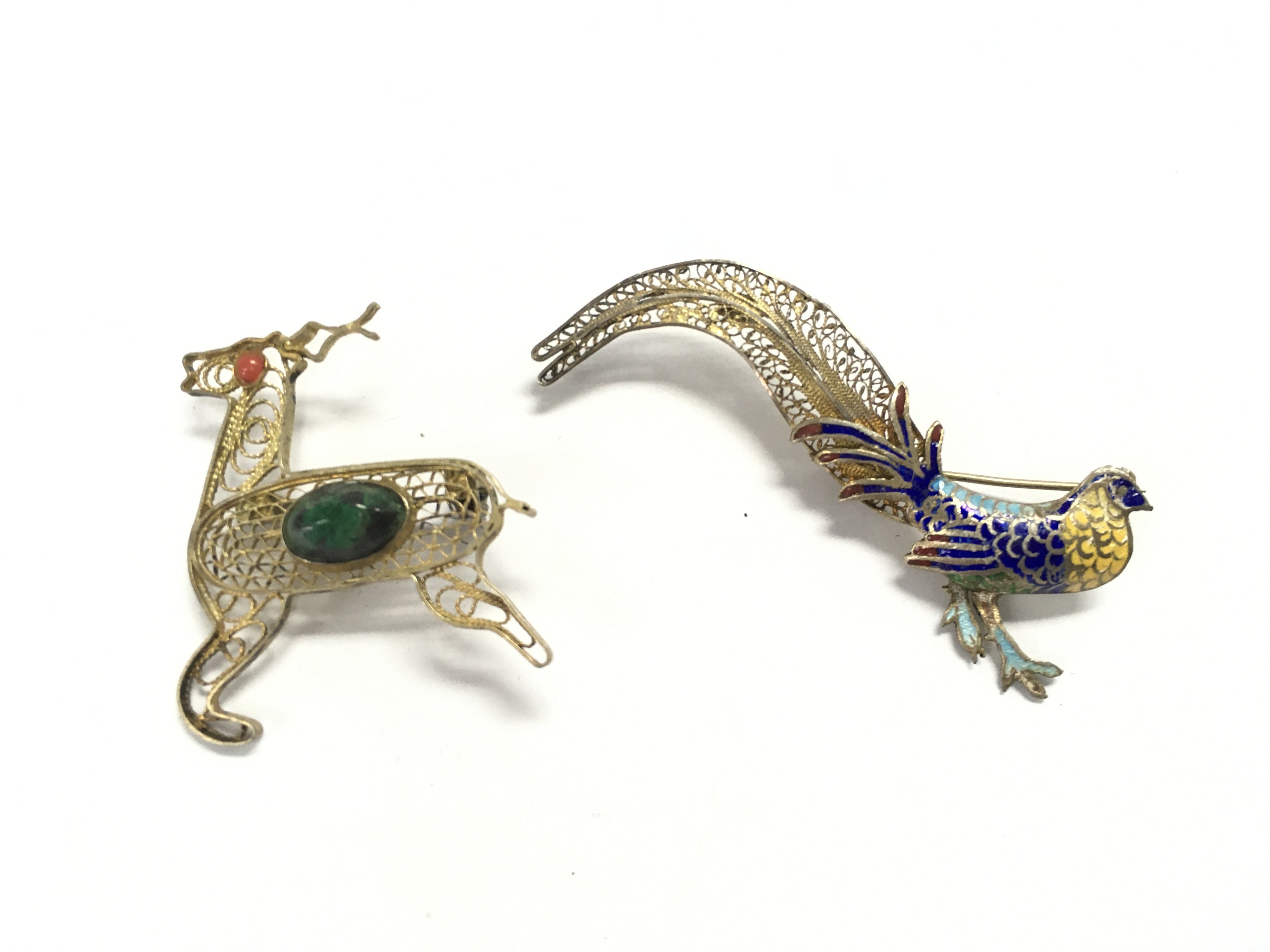 Two silver filigree brooches the deer is set with polish stones and the others is an vintage Art Deco style enamel peacock brooch.