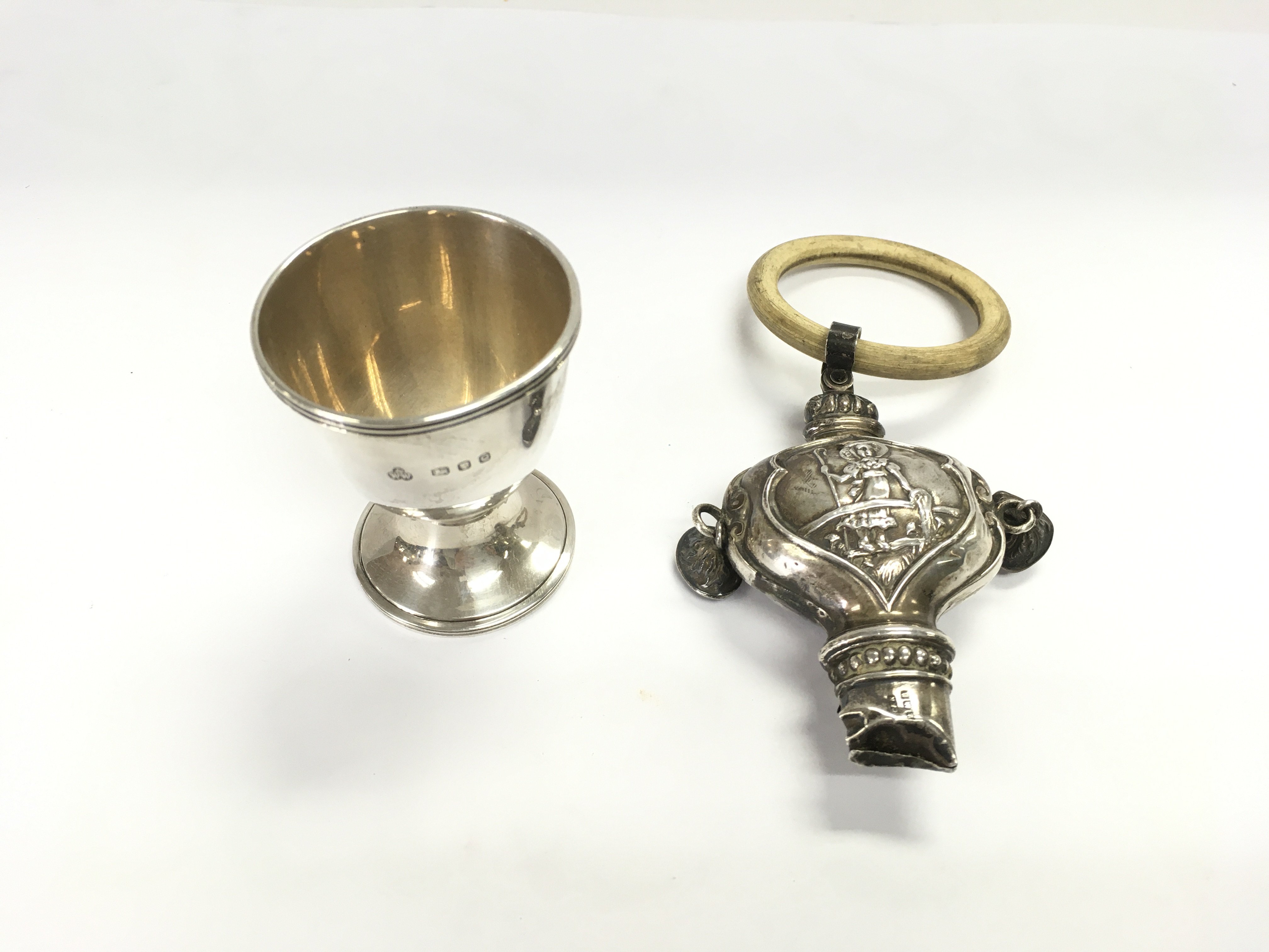 A London hallmarked silver egg cup from circa 1950 weighing 28.81g and a Birmingham hallmarked silver 1926 Rattle 44.25g