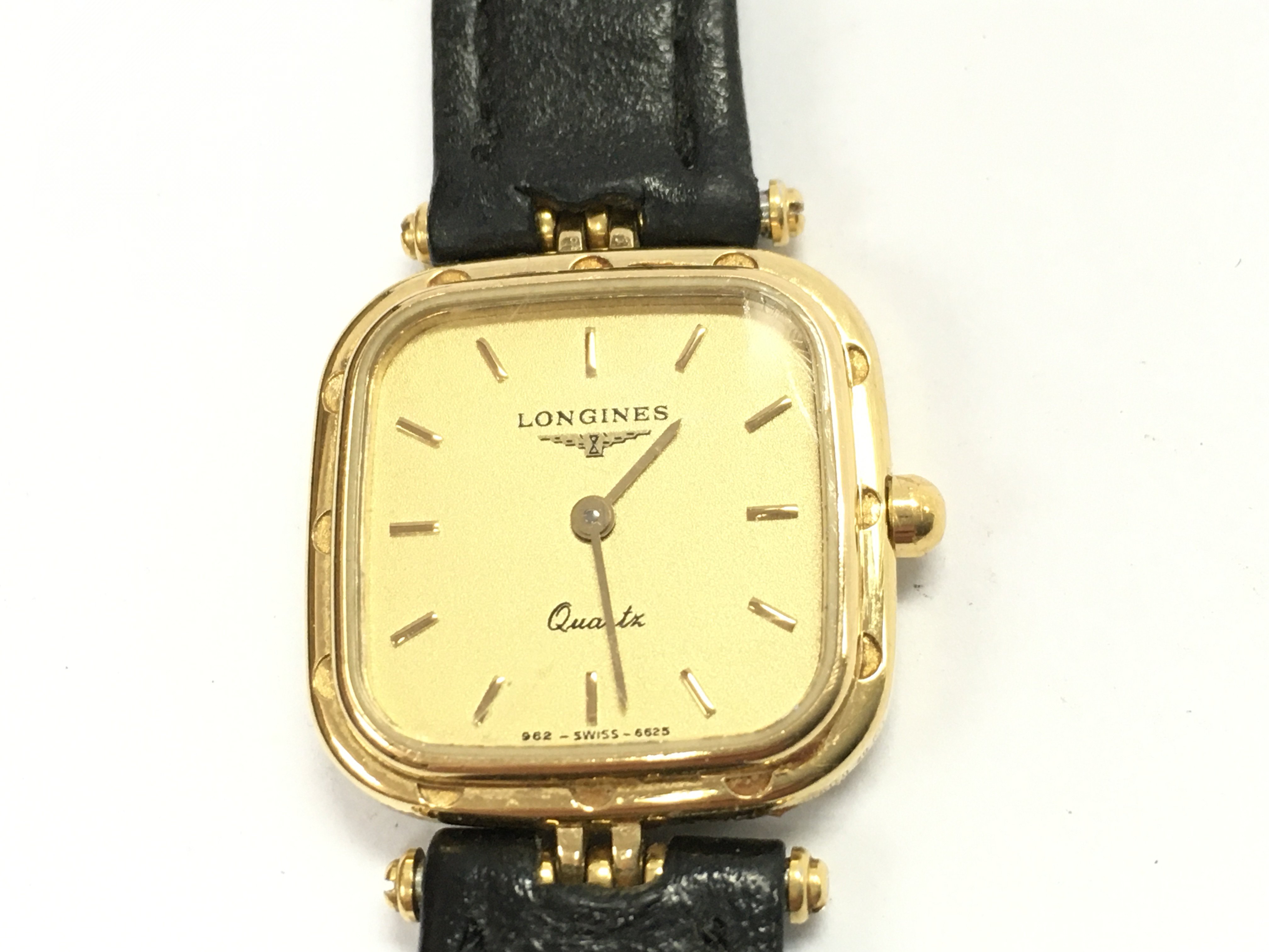 A ladies vintage Longines wrist watch. Quarts movement on black leather strap. Comes with box. Postage B