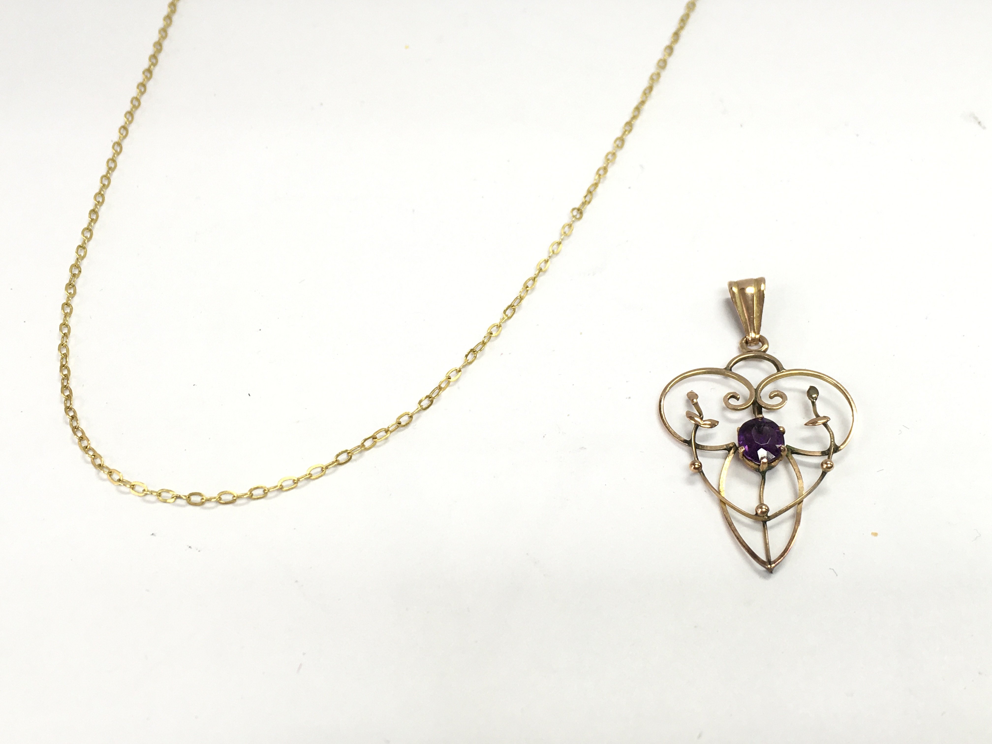 A 9ct gold and amethyst pendant 1.2g and a 14ct rolled gold chain. Postage B