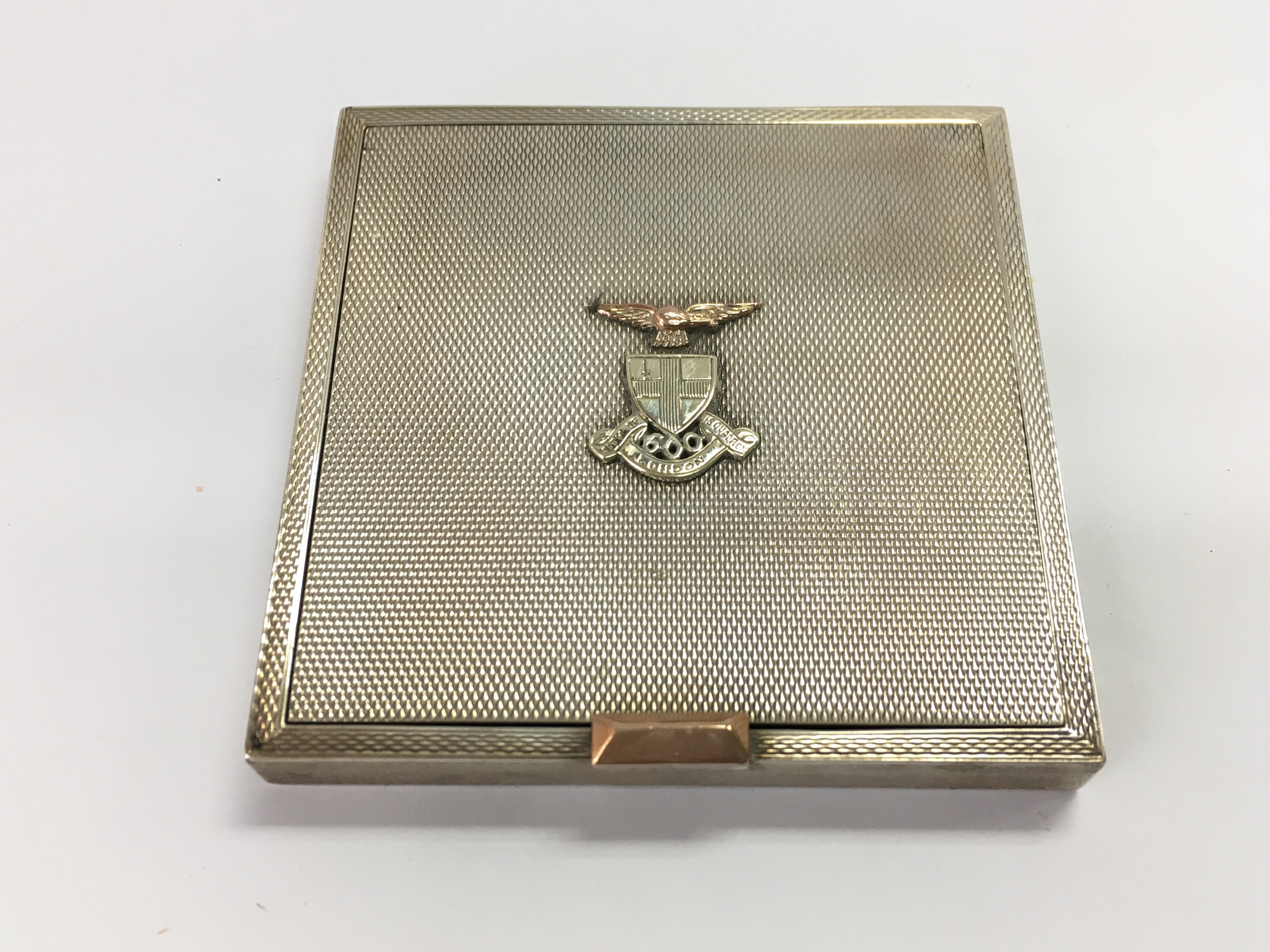 A silver hallmarked compact with a military insignia on the front.