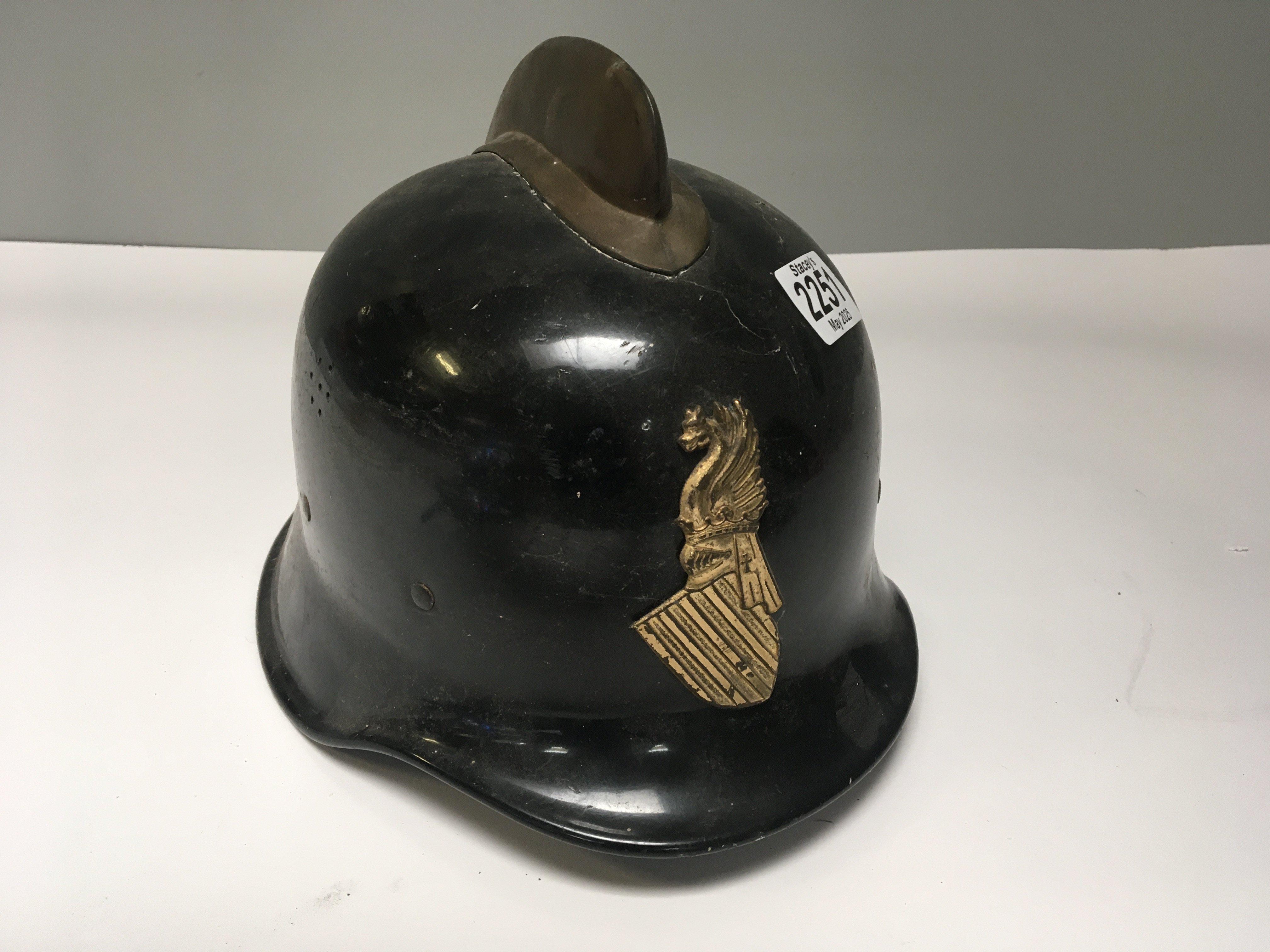 A Vintage French Firemens helmet with applied regional gilt metal badge and original lining.