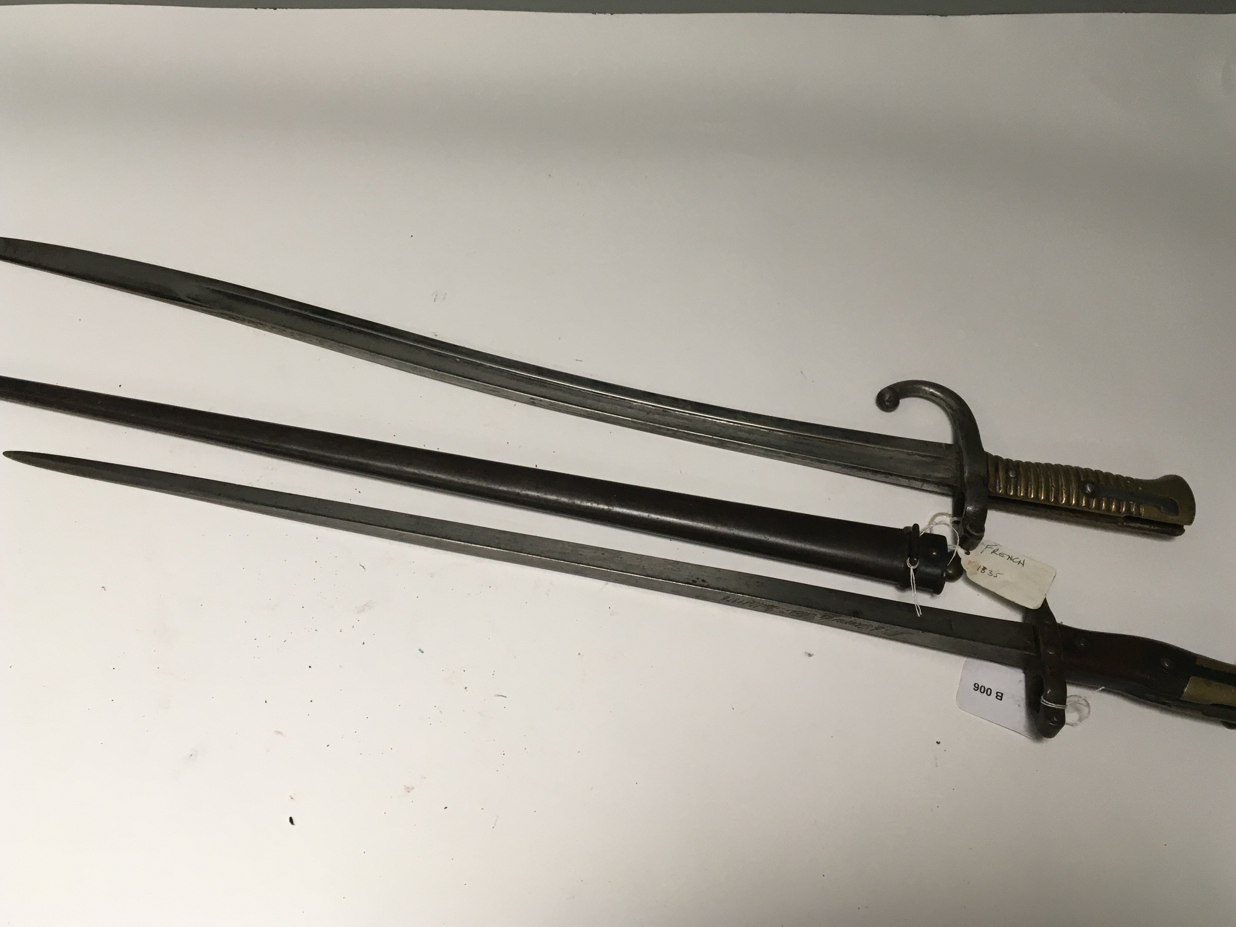 Two French bayonets an 1835 pattern with brass grip and an 1876 pattern with steel scabbard and wood and brass grip both with hook quilon. (2)