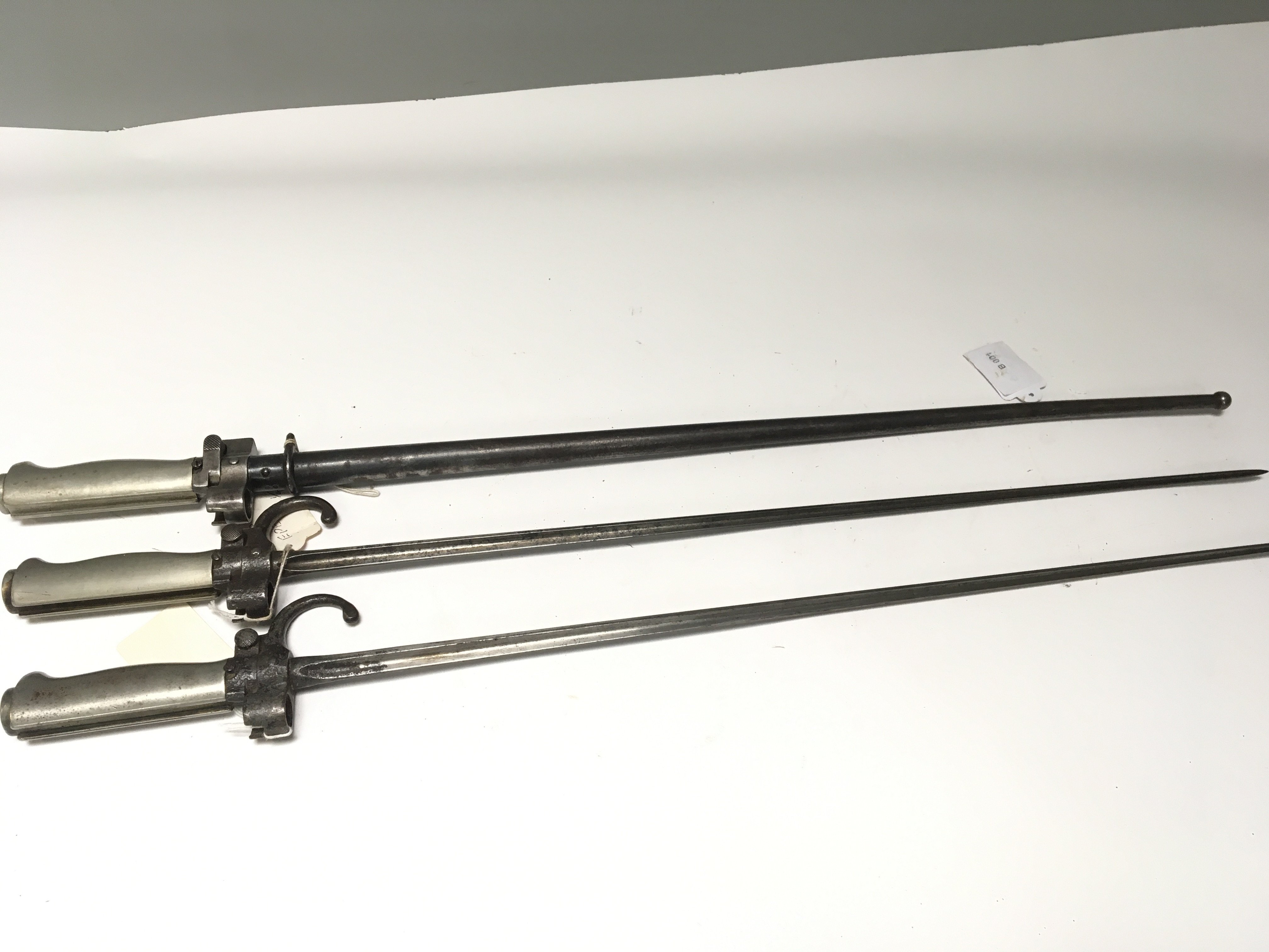 A French stick bayonet numbered E6142 steel scabbard and two other French stick bayonets with hook quilon (3)