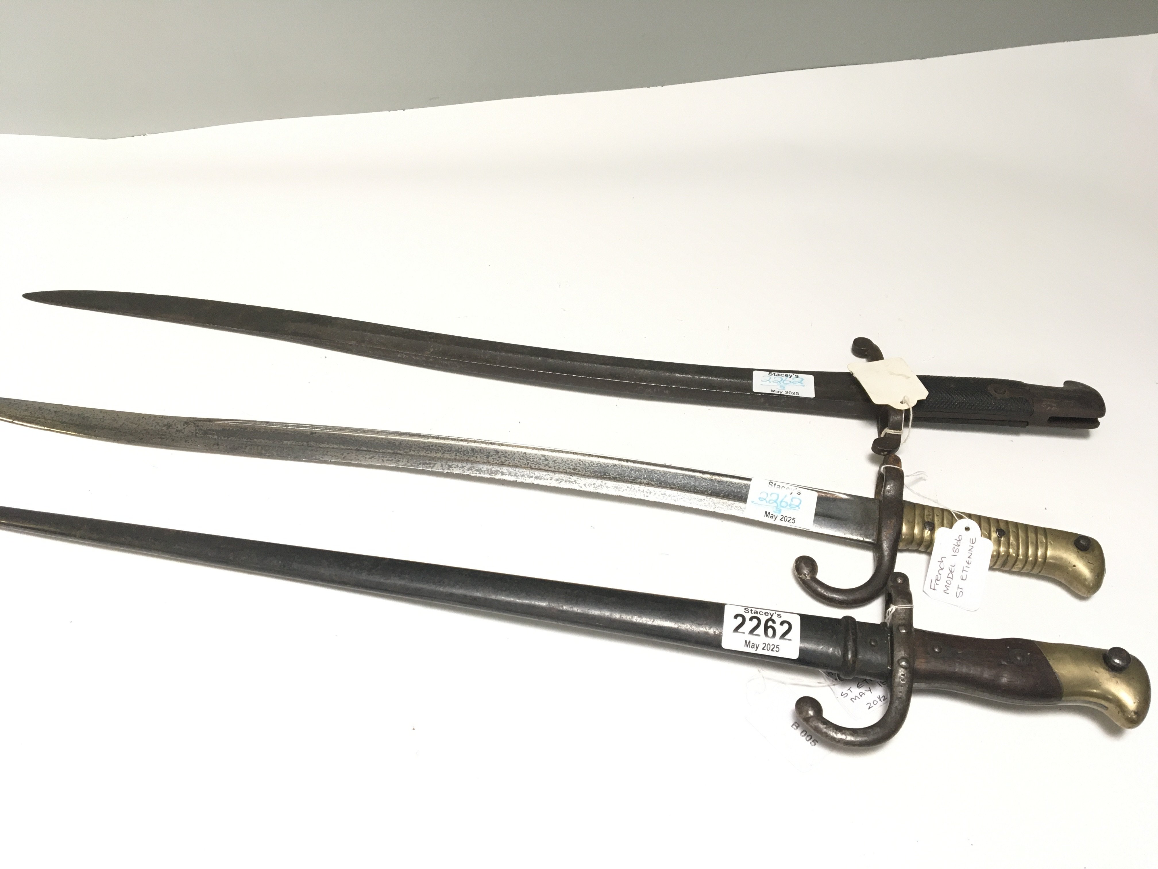 A British 1856 pattern Yataghan bayonet numbered 107 with further small stamp marks on the blade no scabbard a French 1866 pattern bayonet and an 1877 pattern bayonet with scabbard (3)