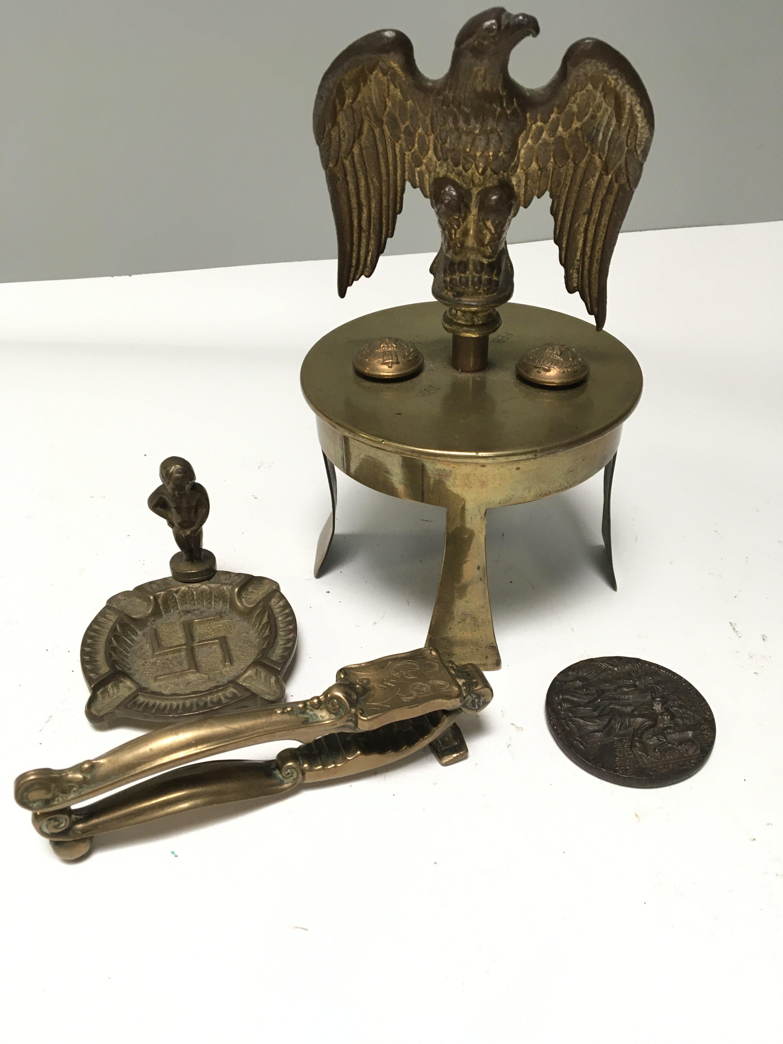 A I world war trench art brass shell top dated 1916 surmounted with an eagle and buttons a Lusitania medallion and Third Reich ash tray and nut cracks. (4)
