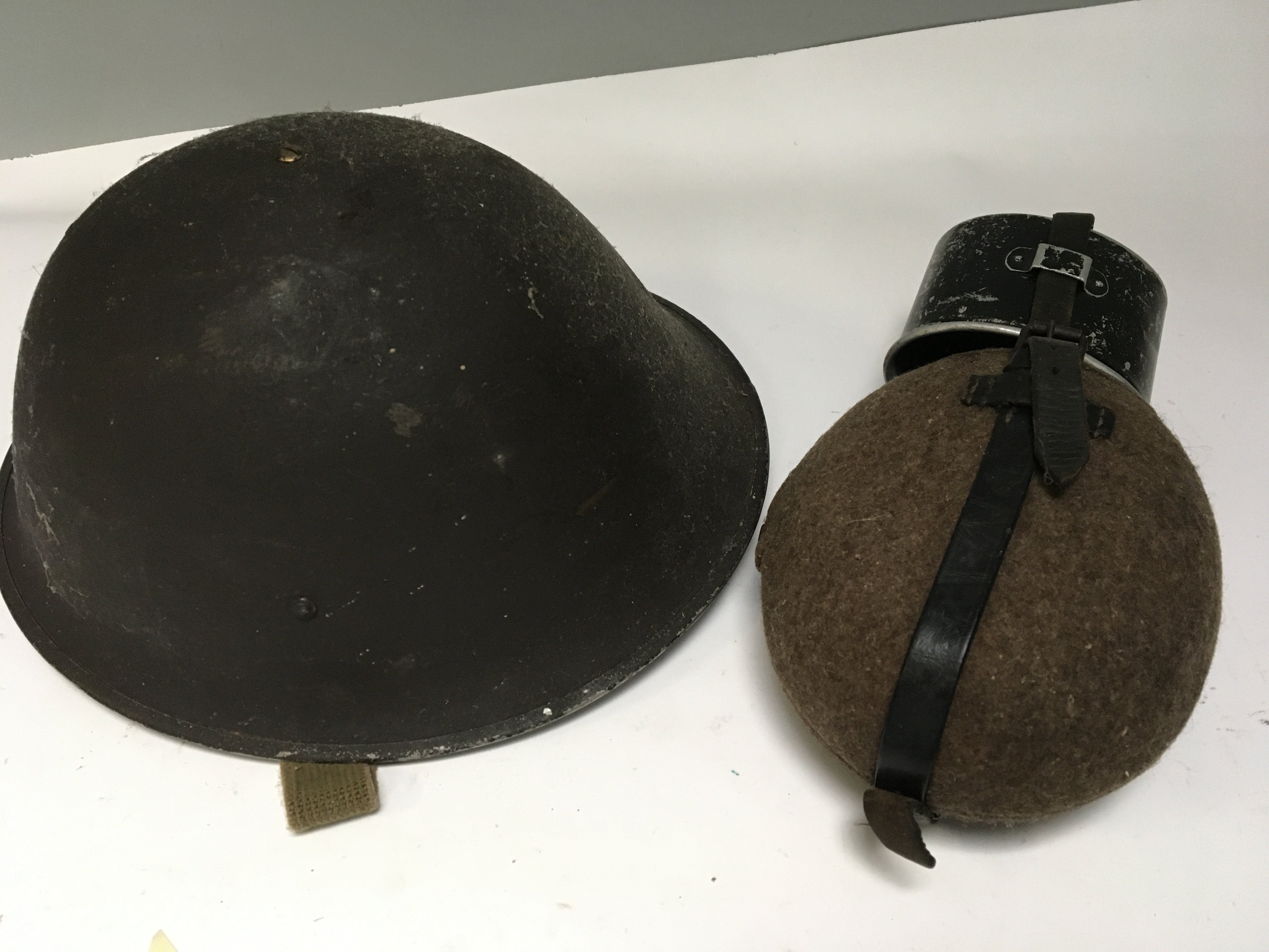 A British Military issue combat helmet worn in Belfast late 1960-70 and a military issue water bottle (2)