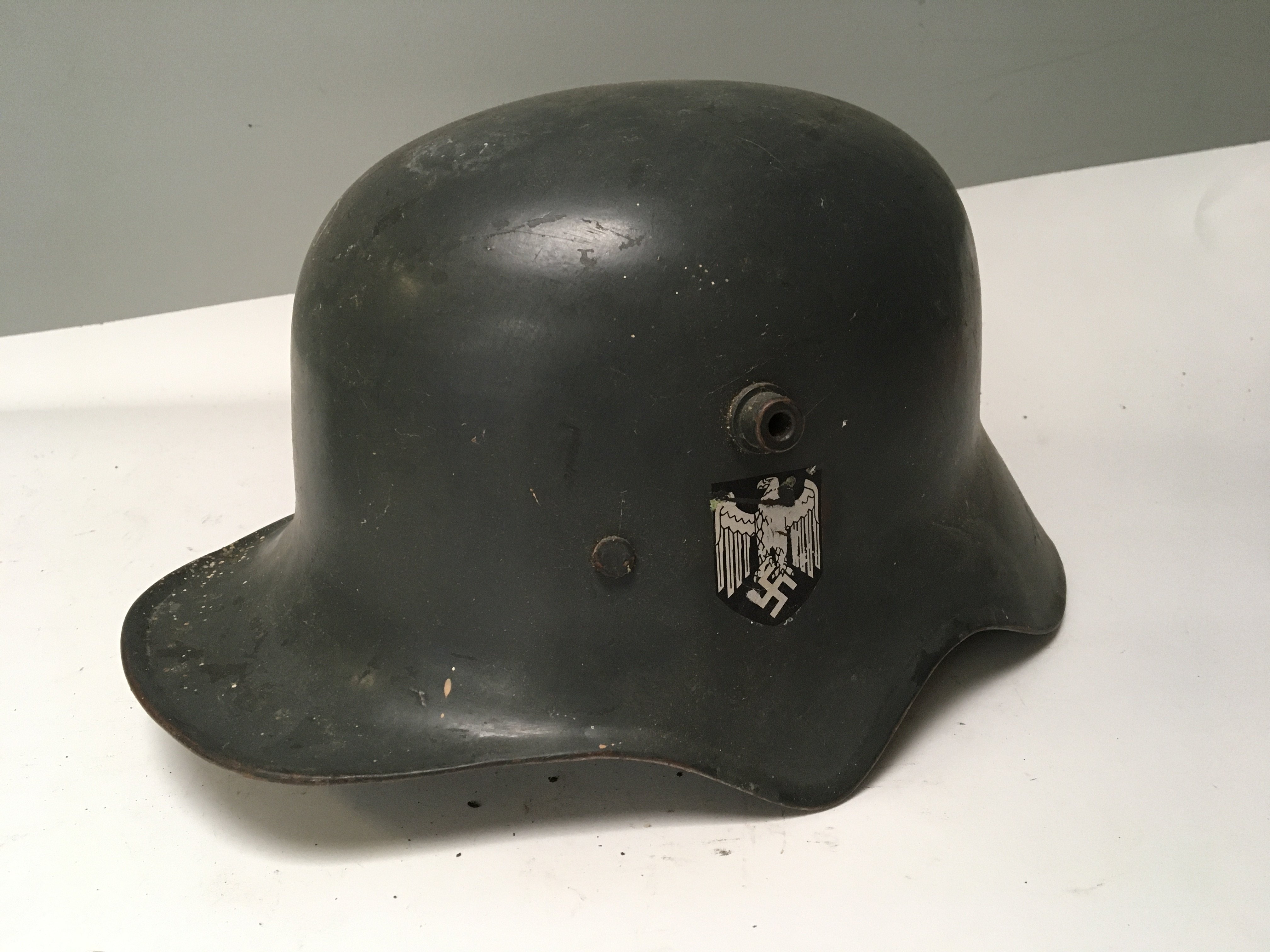 A rare German Transitional Cavalry or Telegraphists helmet. The M-18 helmet has a shaped edge to allow the cavalry soldiers to hear orders whilst in a battle charge. This is a rare genuine example of a transitional helmet used in both I and II world war the helmet with German Third Reich decals folded edge and unusual white liner.