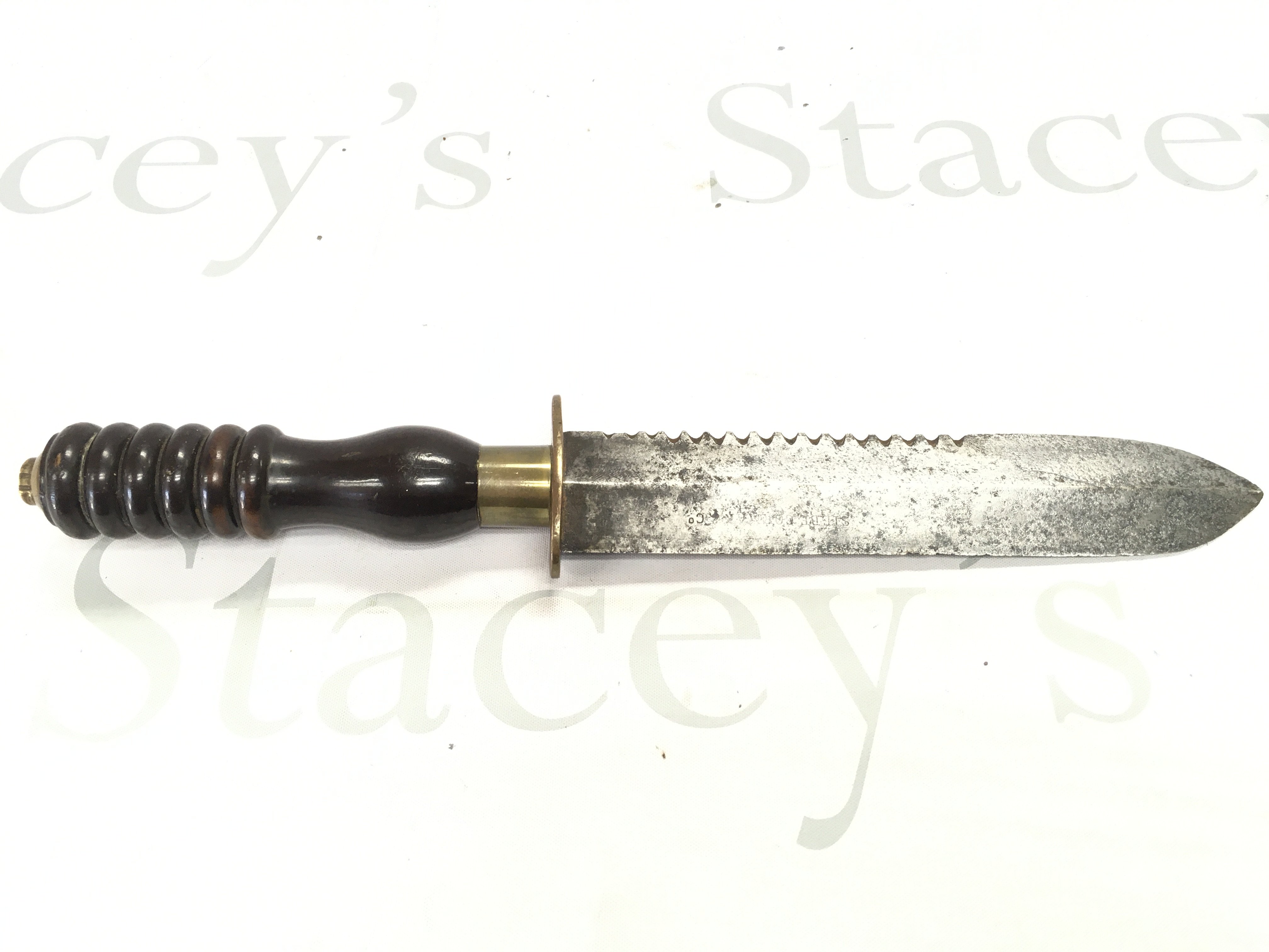 A Siebe Gorman diving knife, with a brass collar, turned handle, stamped makers mark on the blade and a brass sheath. Blade 19cm long. Total knife length approximately 36cm.