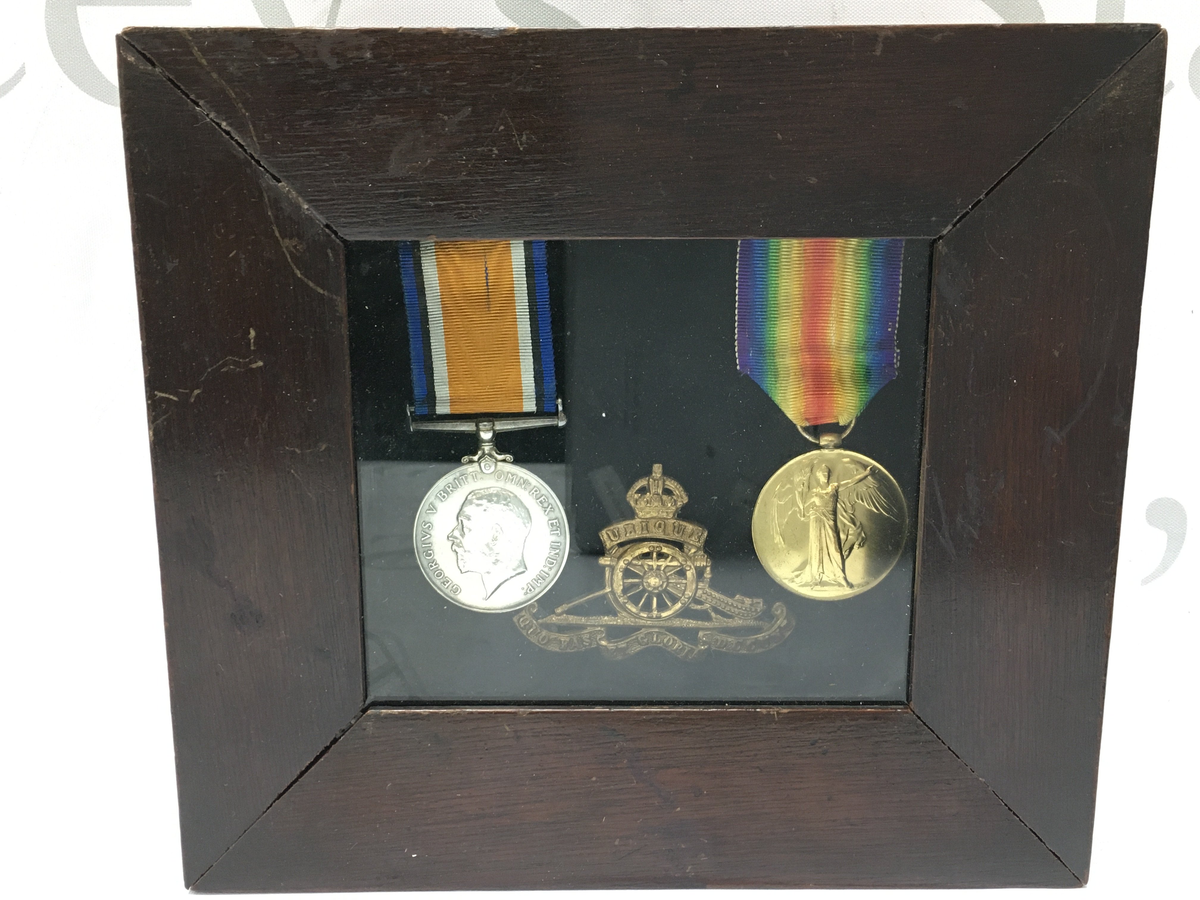 A WW1 medal group including a war and victory medal presented to a Gunner RA William James and a Royal Artillery cap badge in a presentation case. Case dimensions 10x18cm .This lot cannot be posted (postage category A if posted without case)