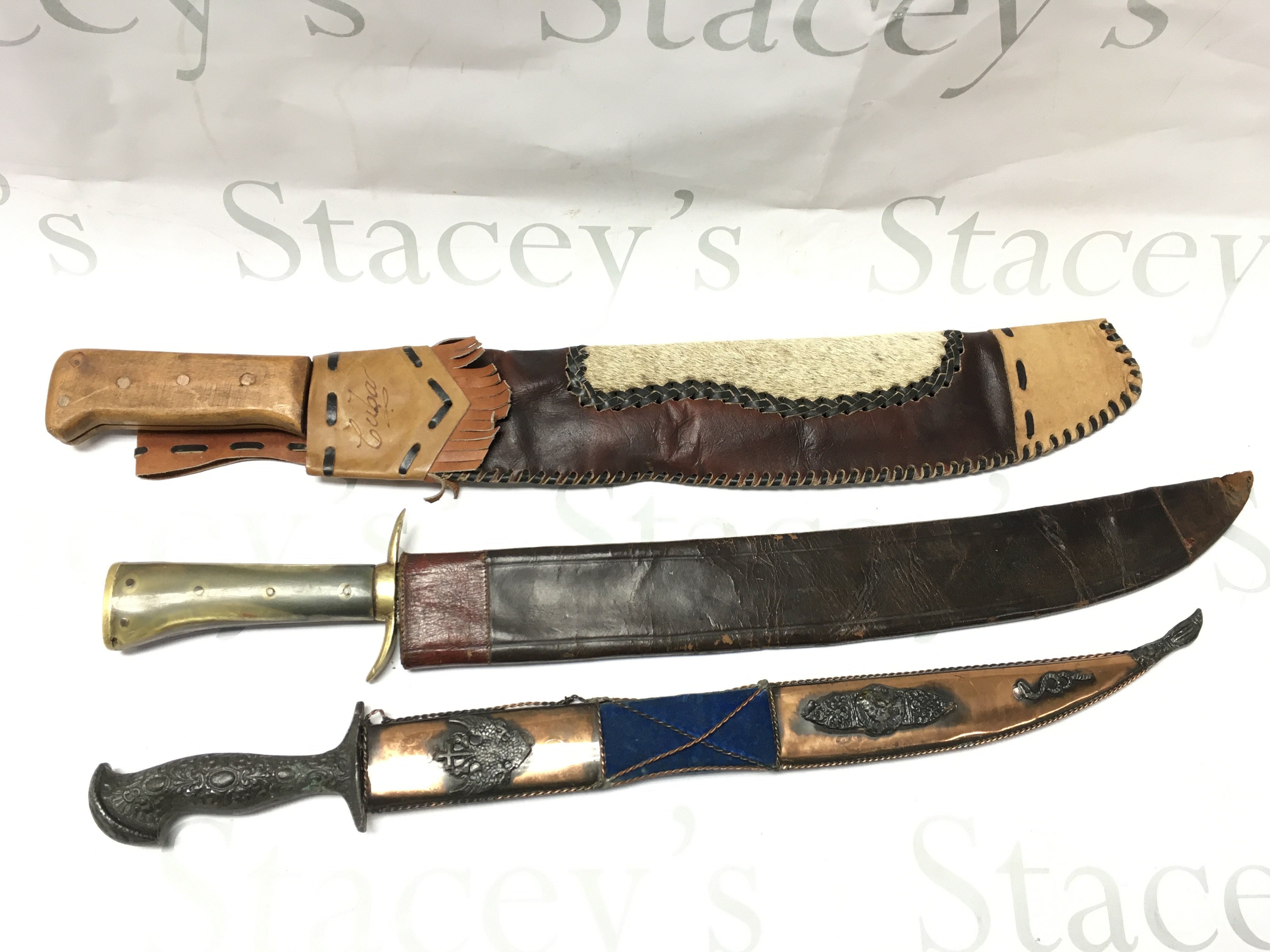 Three Swords including a German hunting knife (60cm long) and a Cuban souvenir machete (59cm long approximately).