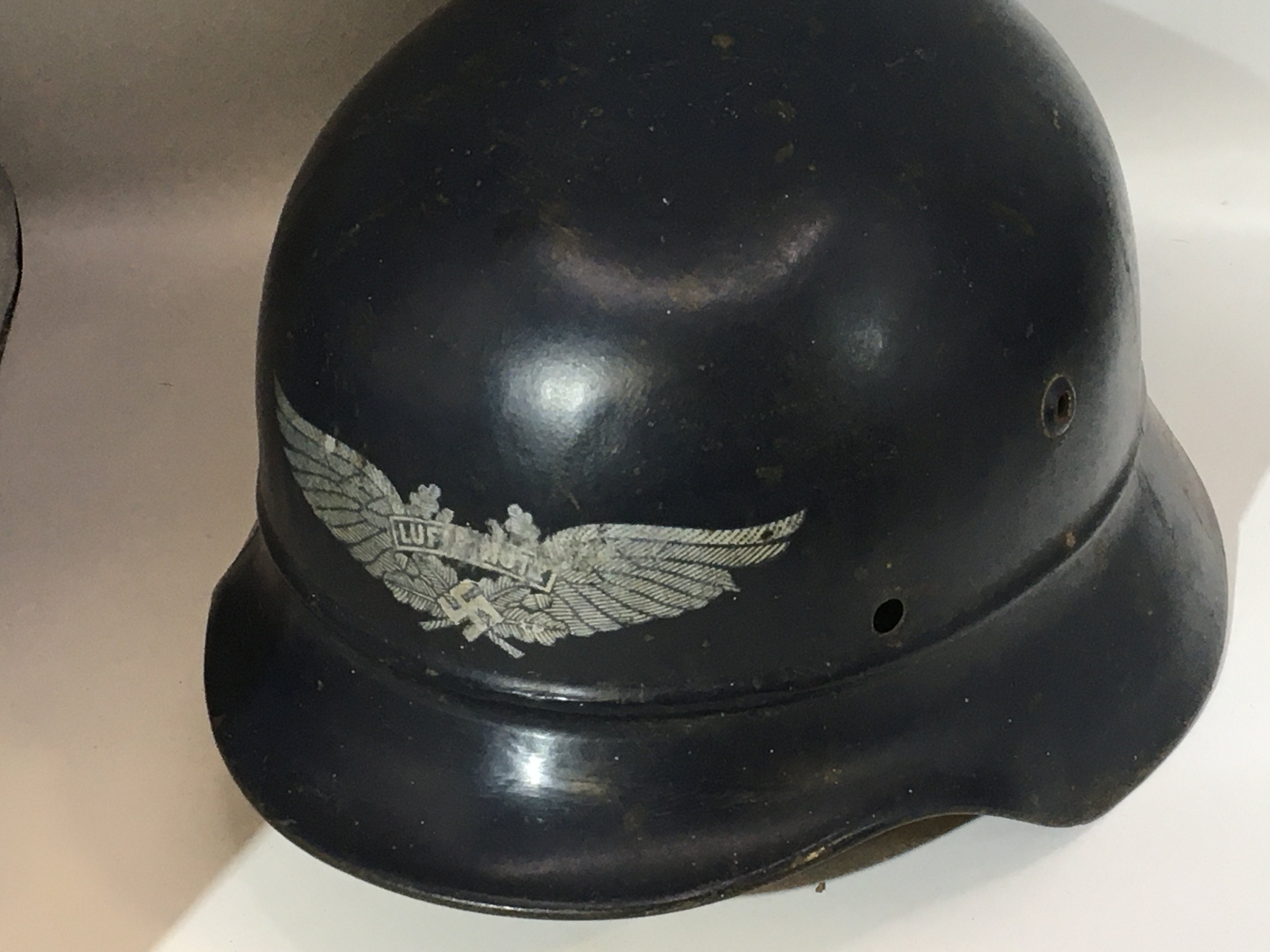 A German Third Reich Luftwaffe helmet with an unusual front decal double winged and central Luftwaffe with a raised press rib above the helmet peak. no lining. With stamped EF64 and 675.
