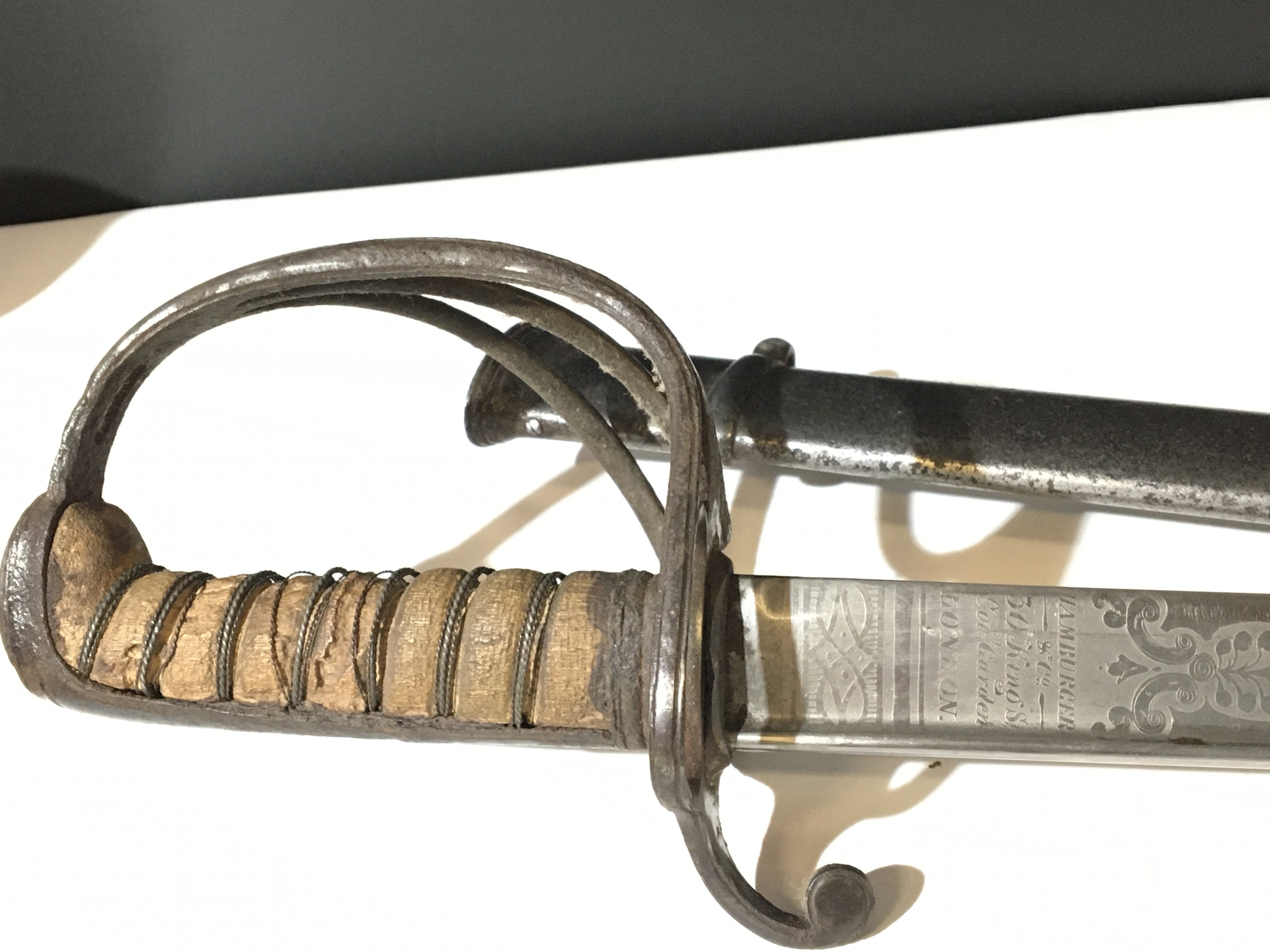 A Victorian officers sword with three bar guard wired grip the blade with makers name Hamburger &Co 30 Kings st London and with Royal Crown patterned on both sides the blade in very good condition. Steel scabbard