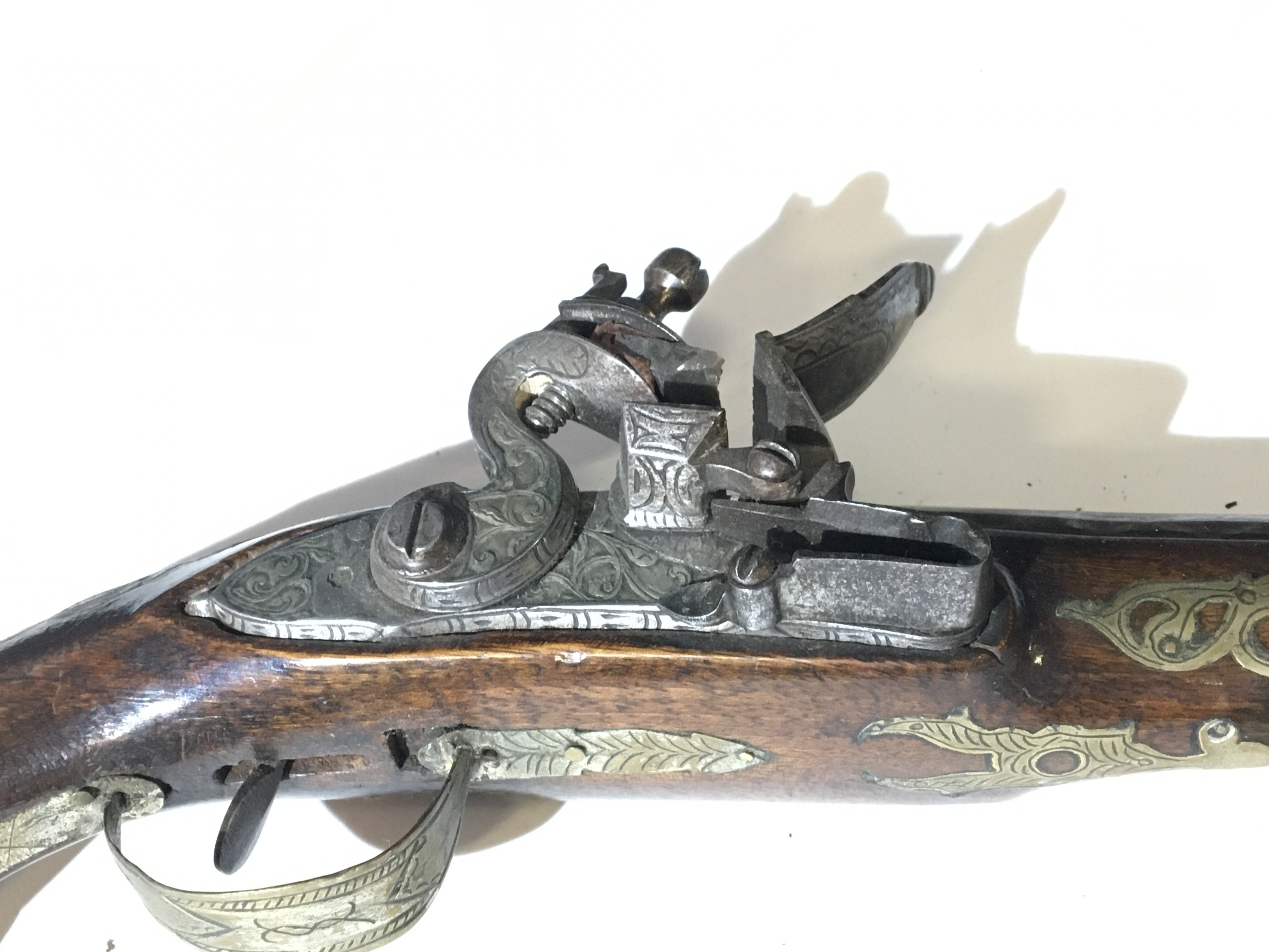 A Spanish late 18th century flintlock pistol with a brass inlaid walnut stock the barrel and action with further ornamentation action functions