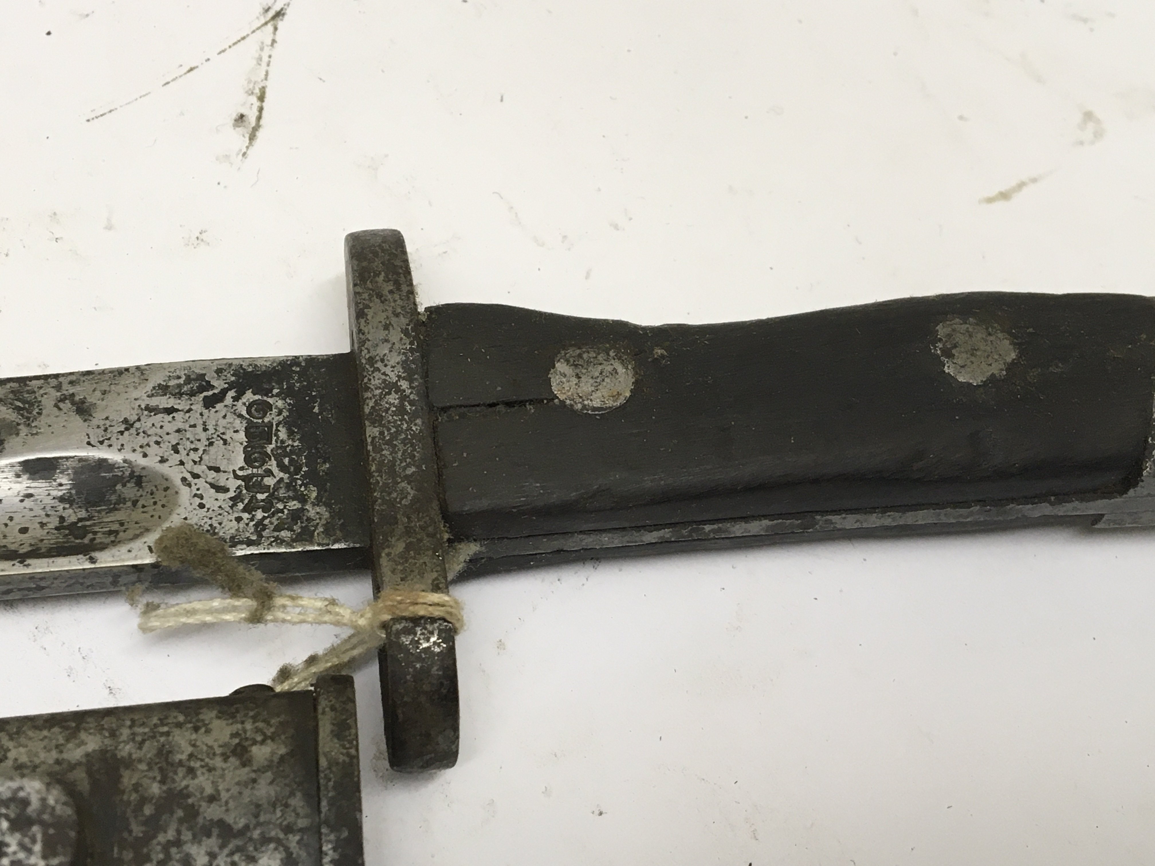 A German K98 German bayonet with wooden grip with unusual marks to the blade. NO RESERVE