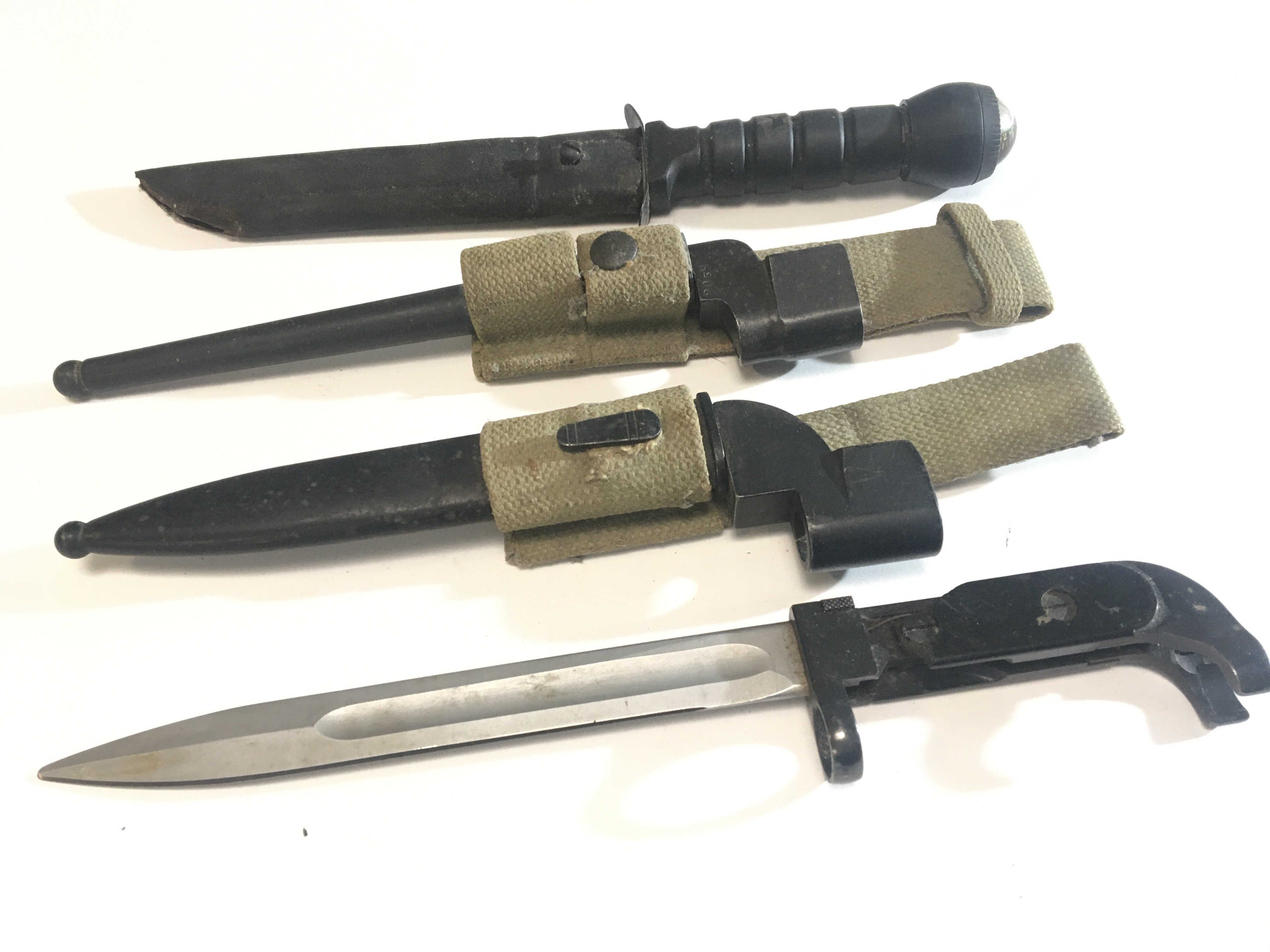 A collection of Military bayonets with woven fabric frogs post II world war issue and a Commando Knife with compass top. (4)