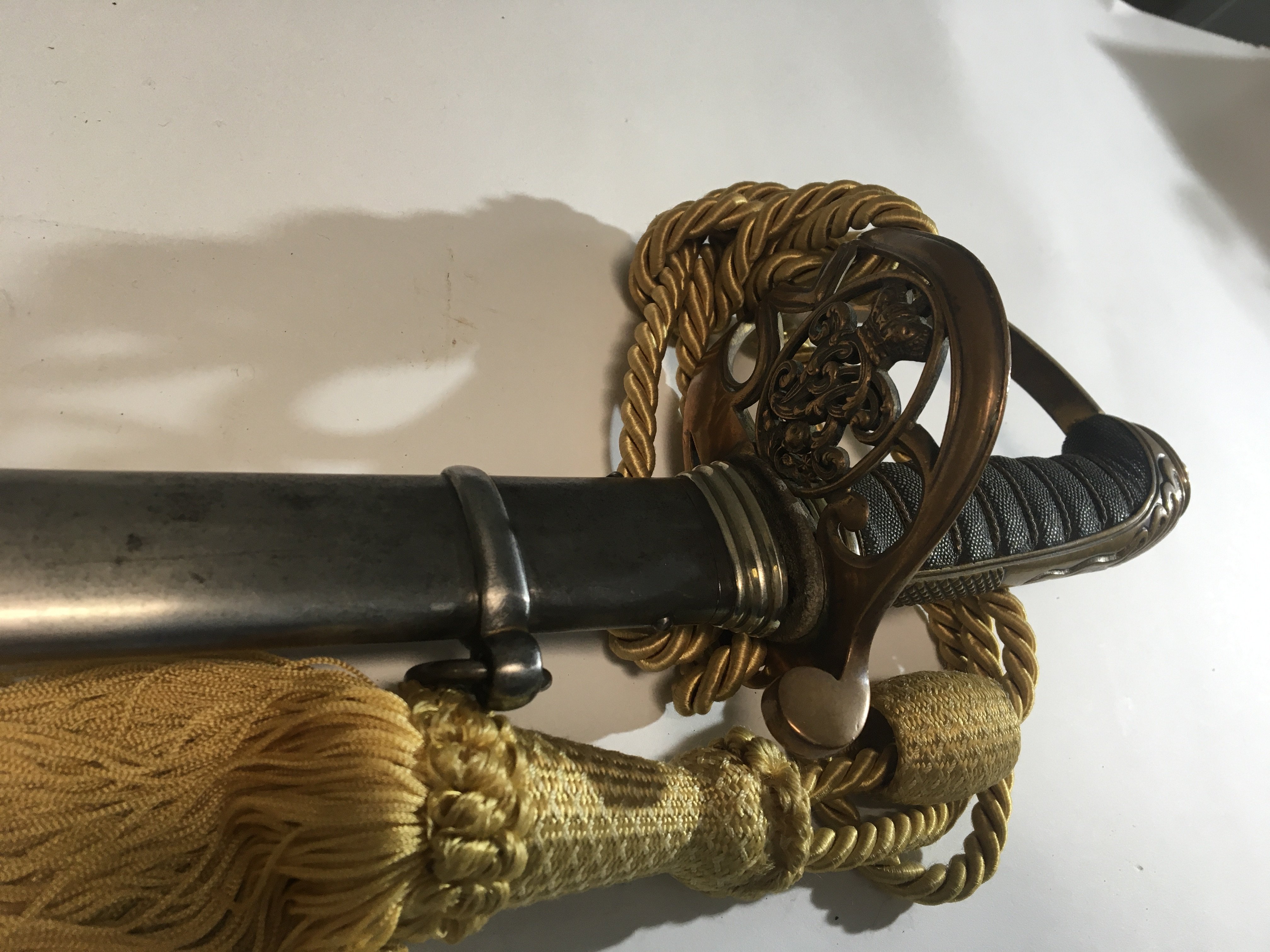 A Victorian officers Cavalry Sword with a brass cross guard with Victorian Cypher bound grip the blade with further ornamentation maker M Stewart Barron in Furness steel scabbard.
