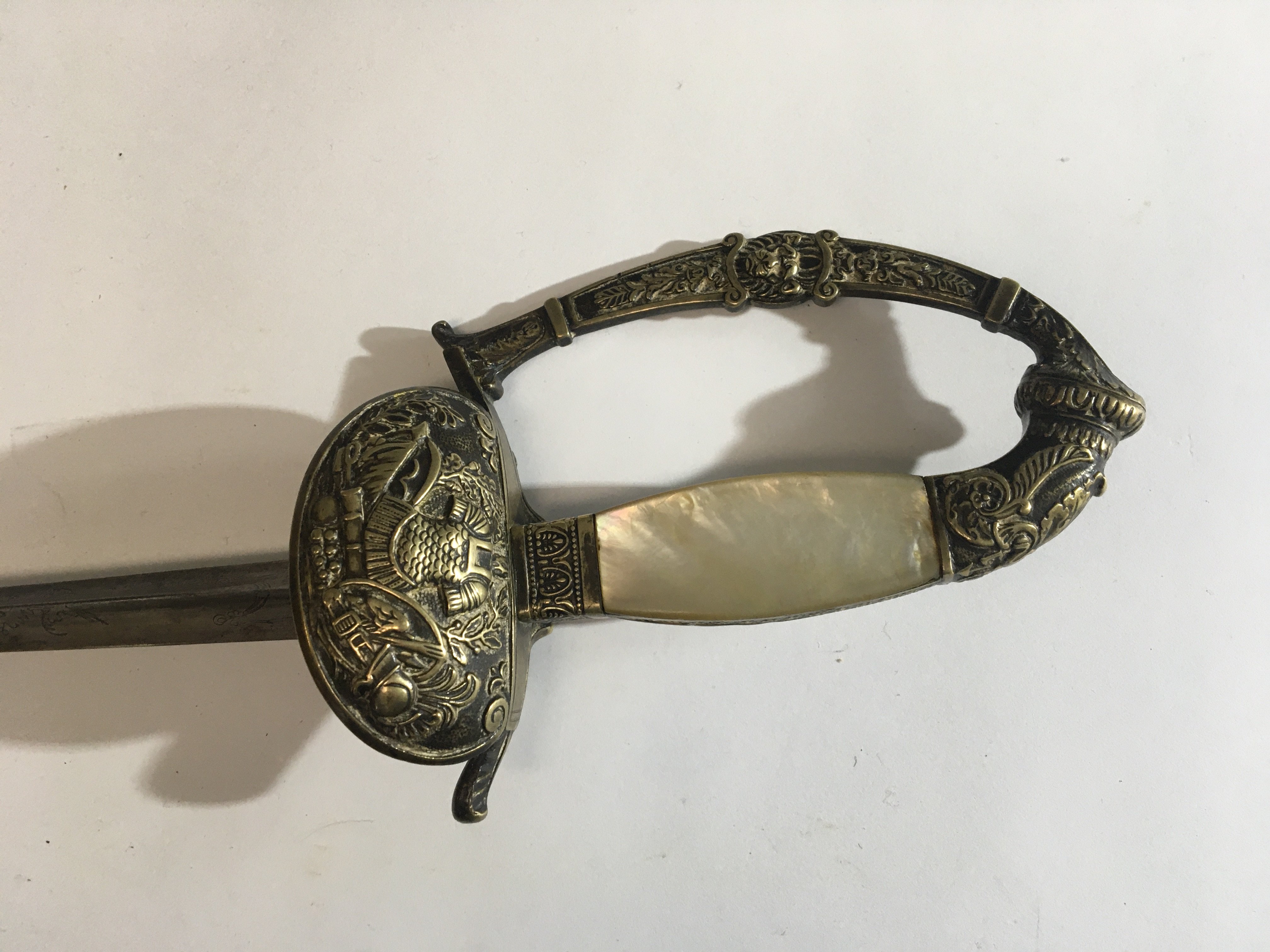 A Court sword possible Italian with mother of pearl grip with ornamentation of Roman influence and patterned blade.