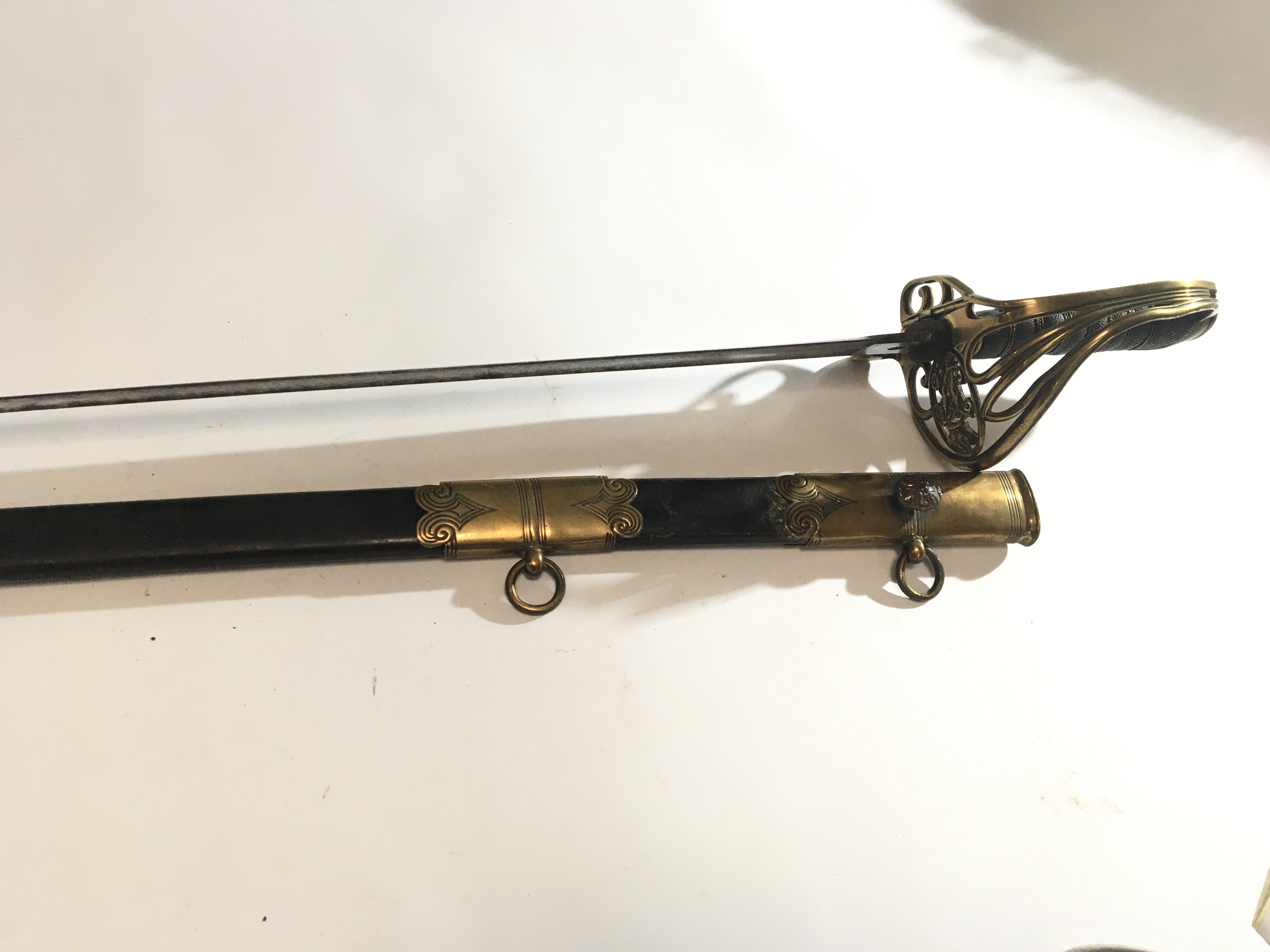 A British Navel officers sword circa 1830 the Guard with Royal Cypher the blade with elaborate decoration maker J Henderson Taunton leather scabbard with brass mounts good condition in keeping with age.