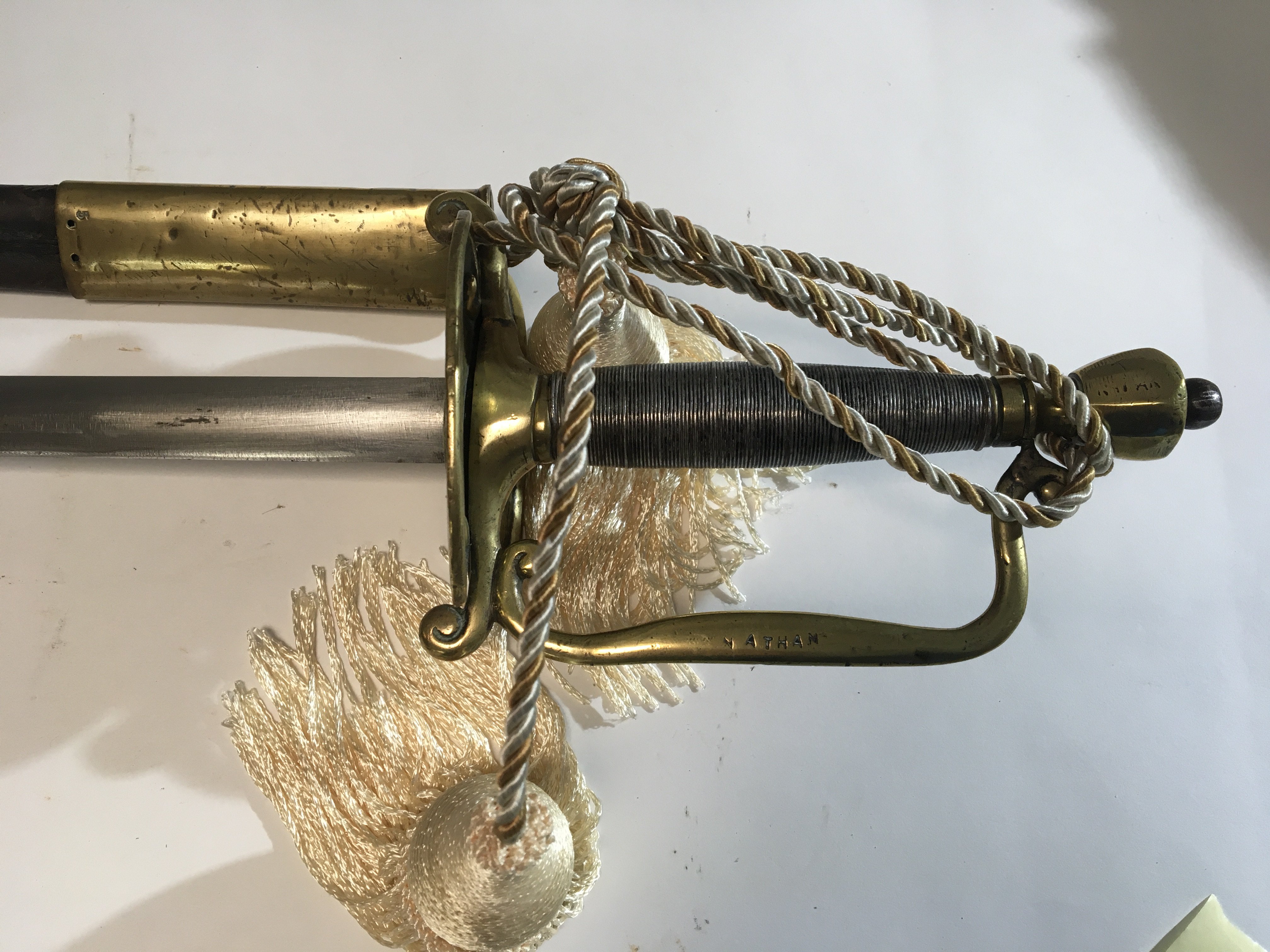 A steel and brass sword with wired grip stamped Nathan with a brass mounted leather scabbard.