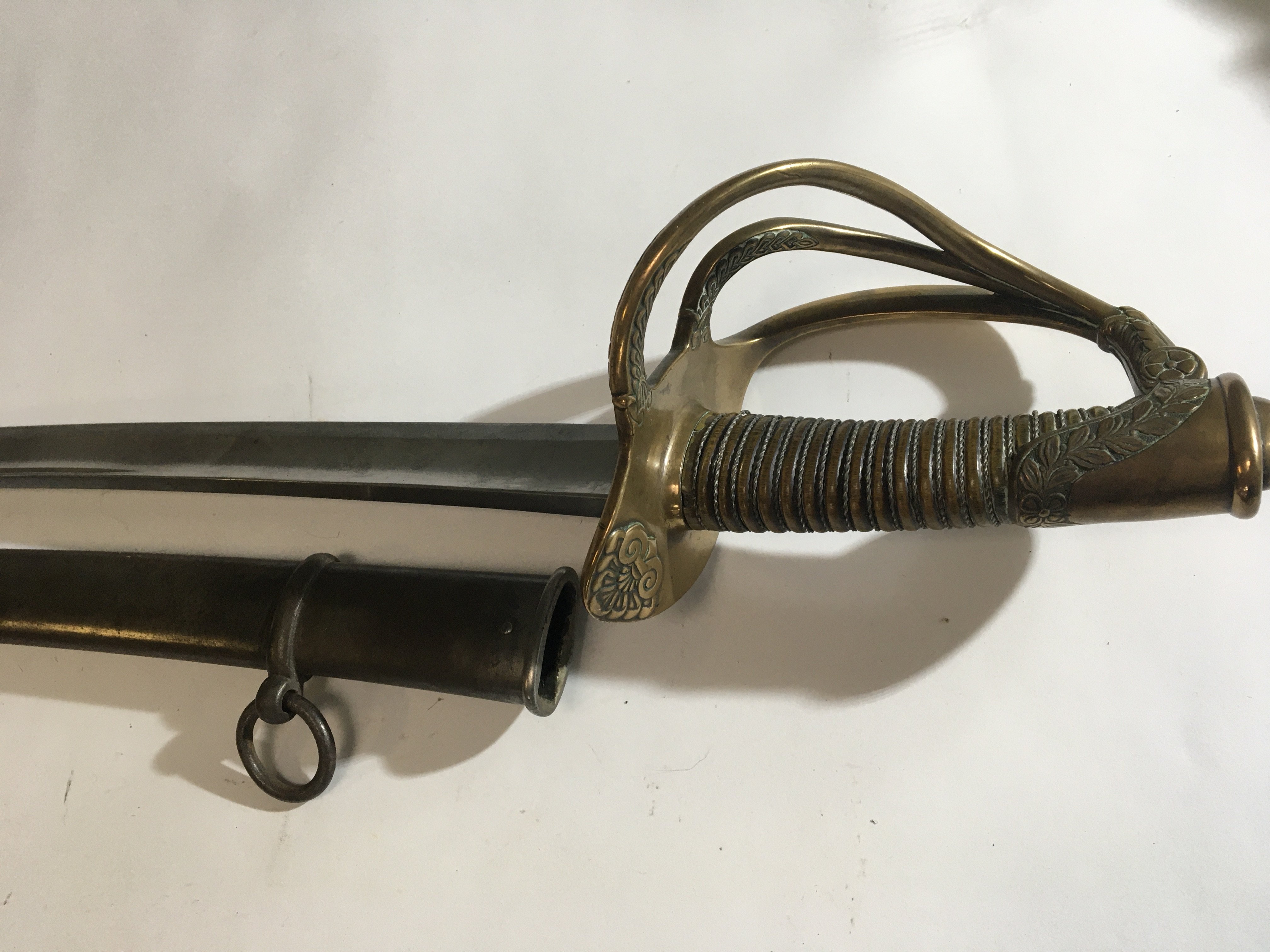 A Saber Cavalry sword with wire grip open basket guard with folate ornamentation steel scabbard.