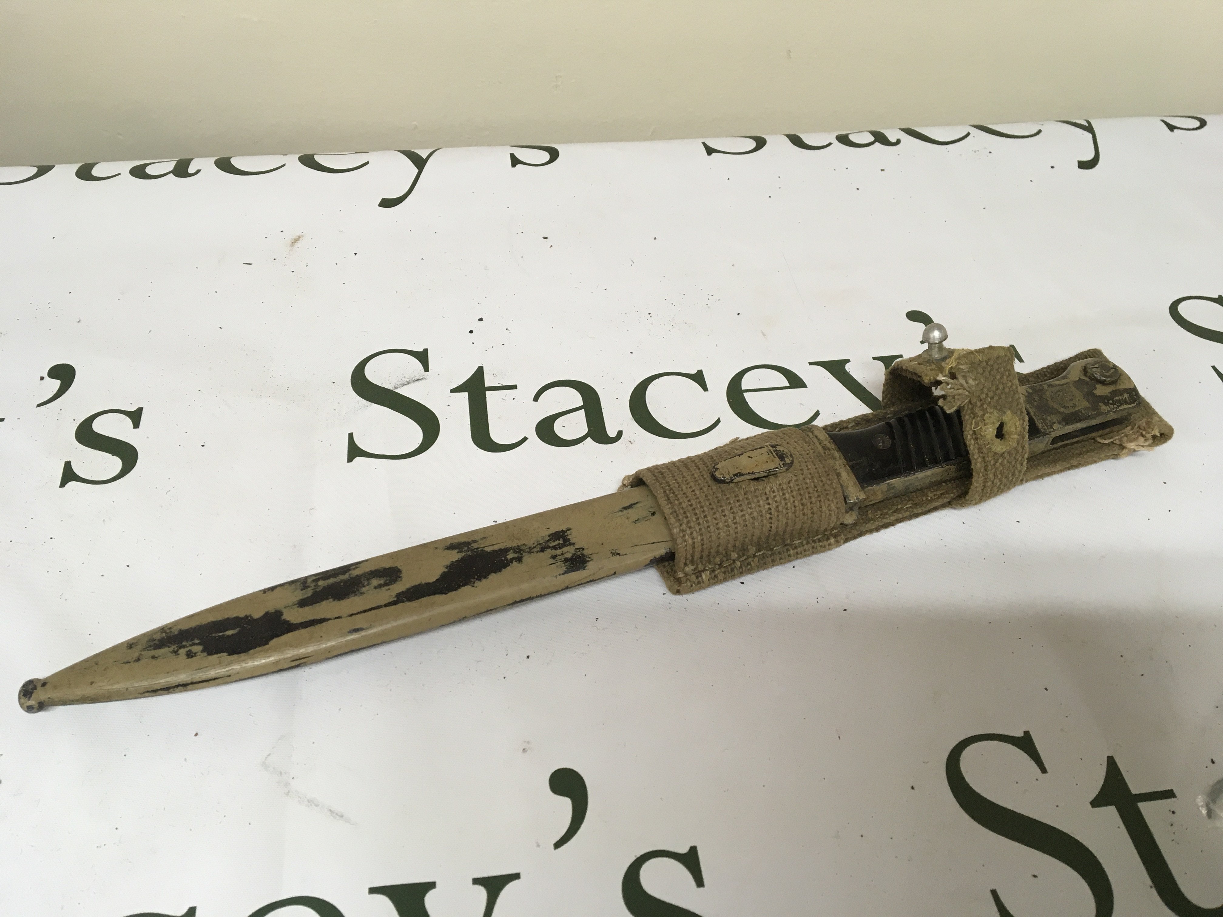 A Very good Example of a German Third Reich Afrika Korps bayonet with attached woven frog. the top side of the bayonet with Afrika Corps stamp the bayonet blade double sided number4874 m and Wasw stamped the metal scabbard and top grip painted in desert colour