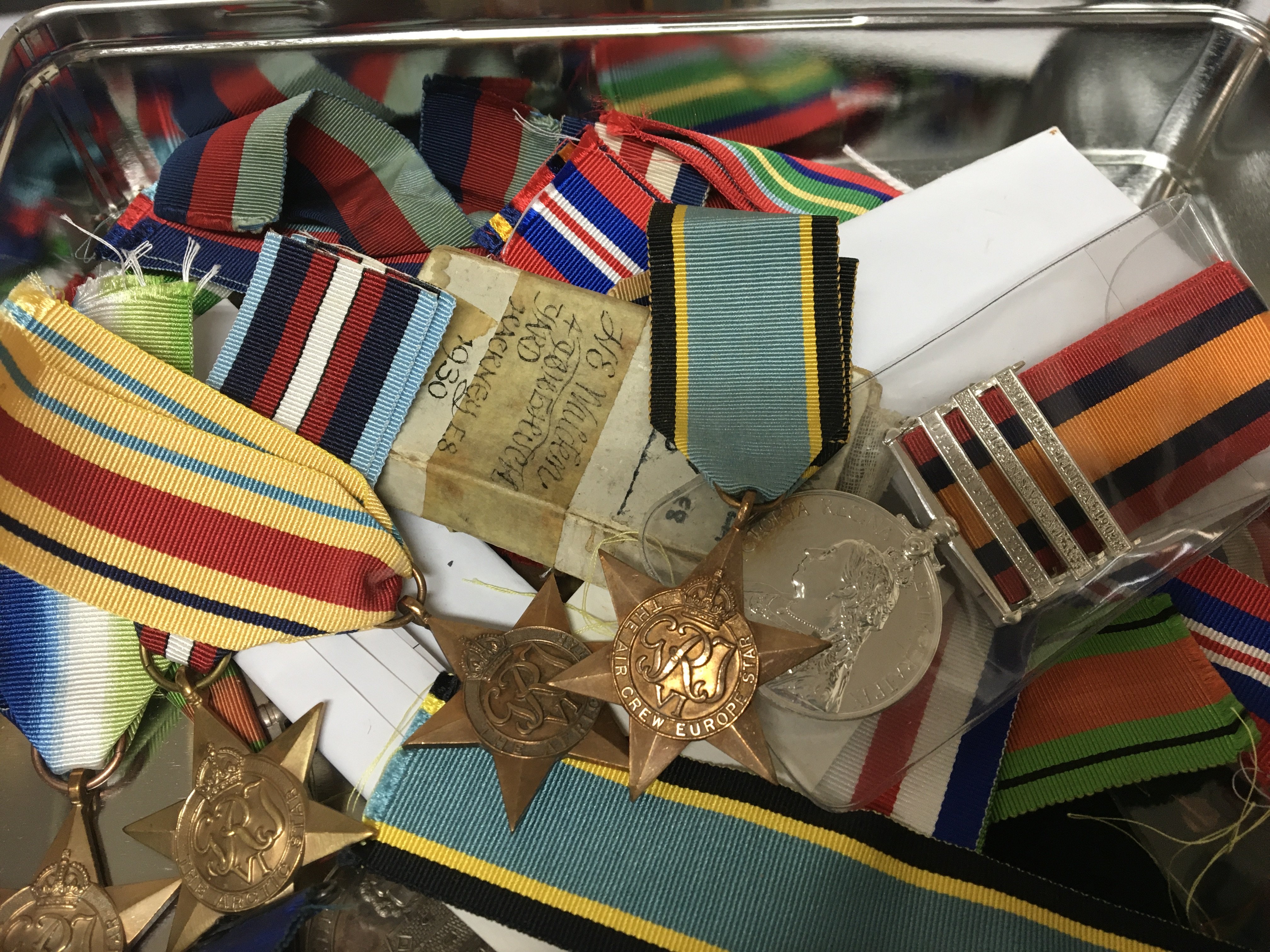 A tin containing II world war medals and retrospective copy II world war campaign stars ribbons and other medals a mixed lot.