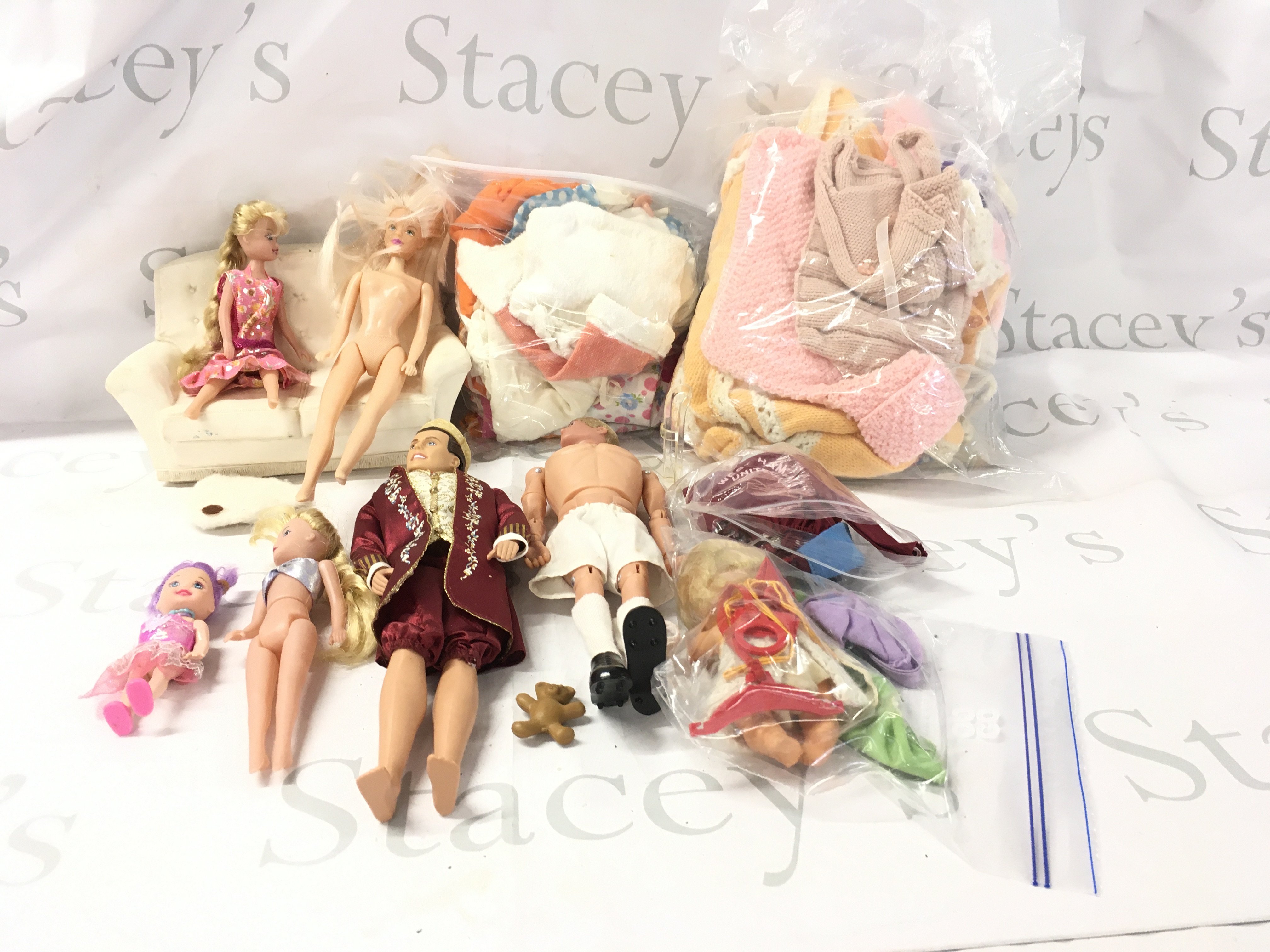 A collection of dolls plus action man with 3 bags of clothes. No reserve