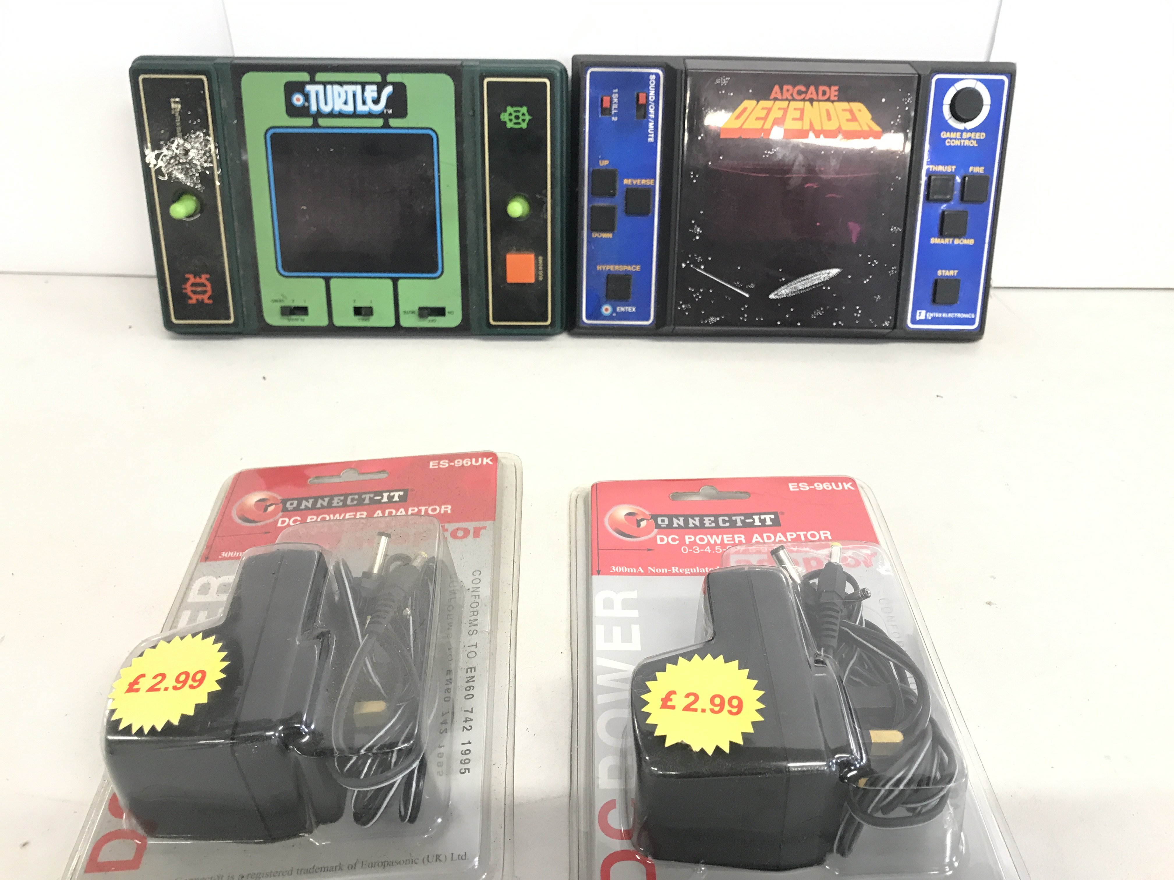 A Entex Electronics Defender Hand Held Console And A Turtles Game. With 2 Transformers.