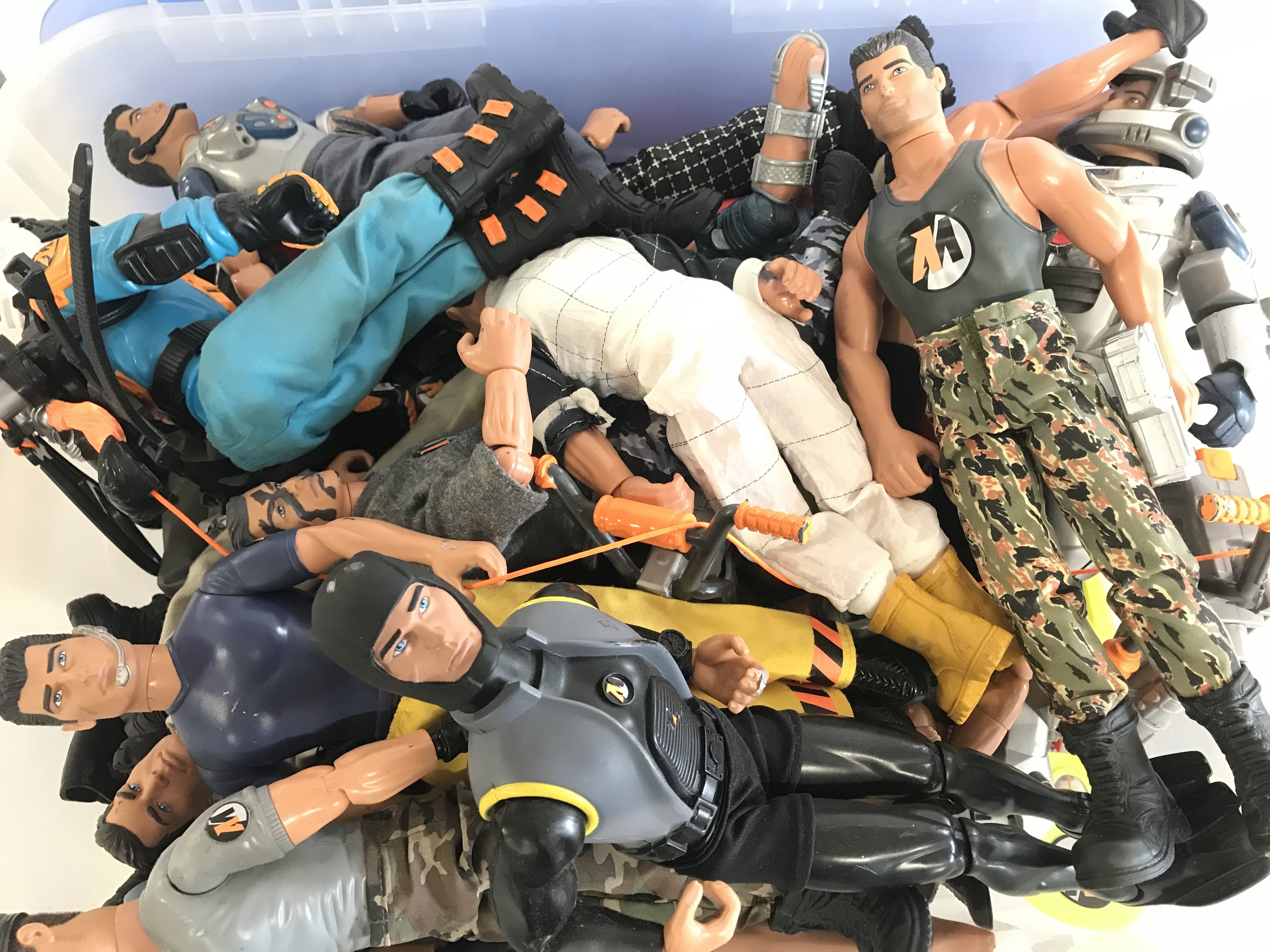 A Box Comtaining A Collection Of Modern Action Men With Accessories.