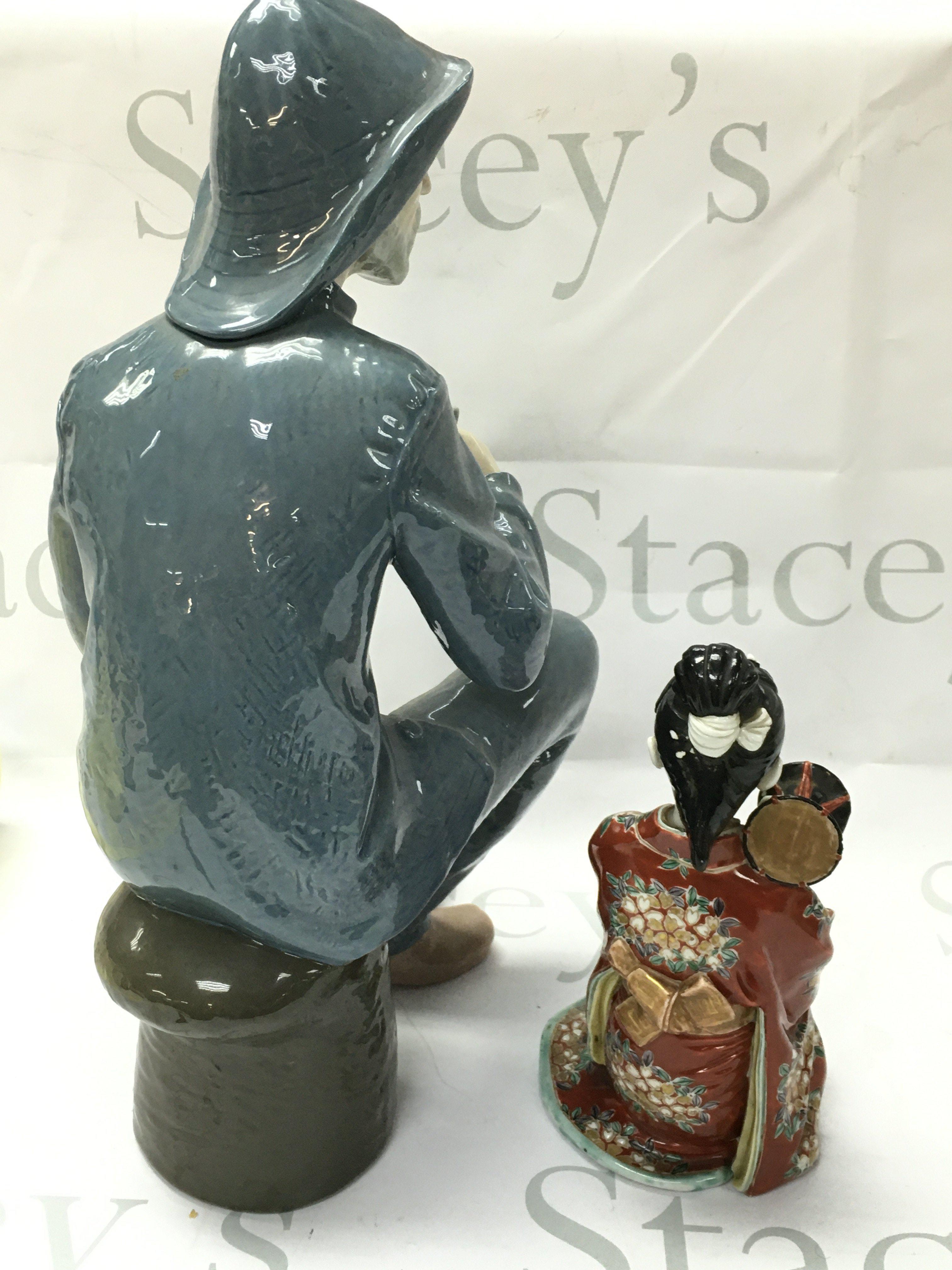 A large Nao porcelain Old Fisherman with a pipe figure and a 20th century Japanese Geisha figure. No obvious damage or restoration This lot cannot be posted