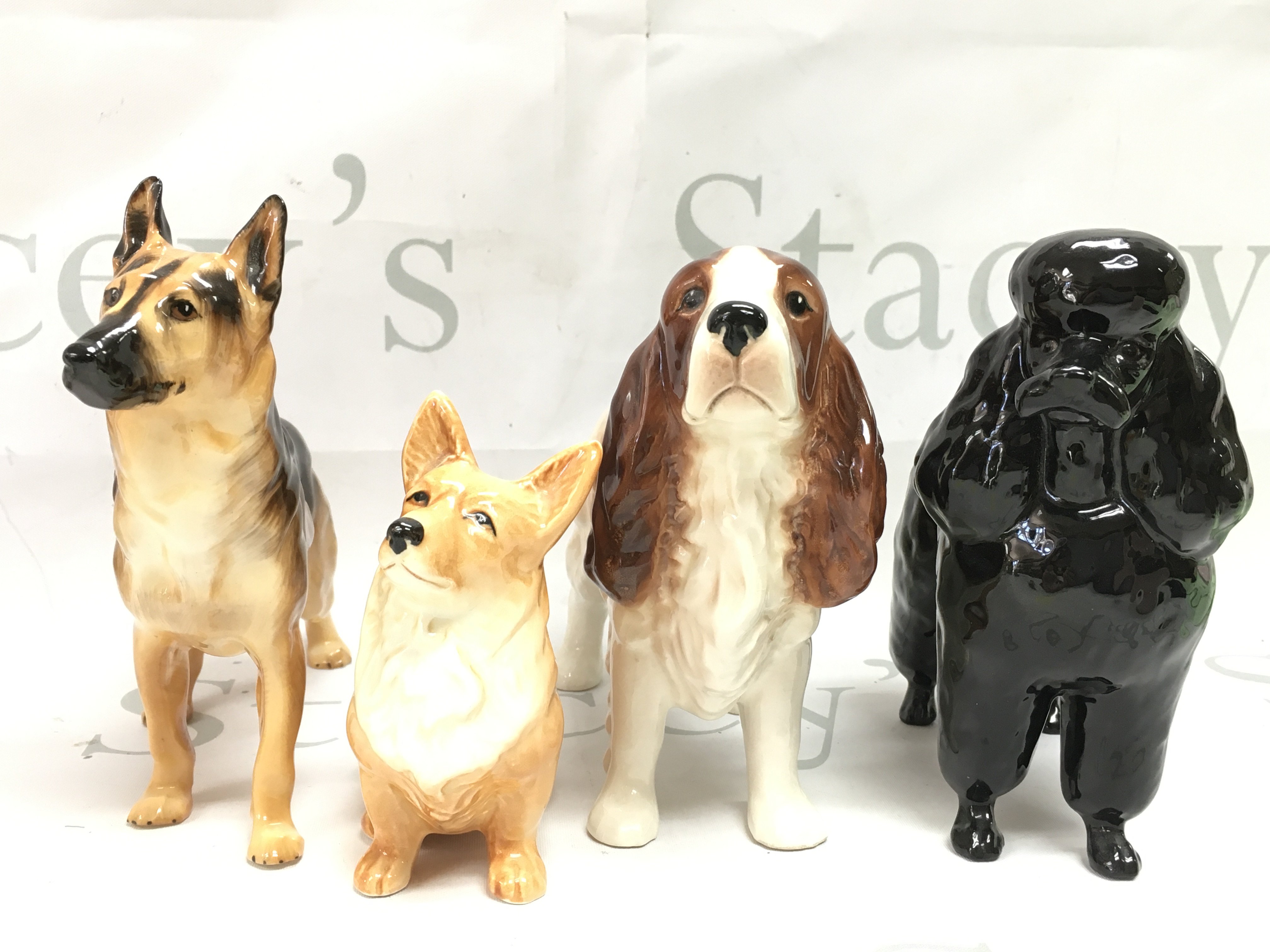 Four porcelain dog figures including Beswick, Sylvac and Royal Doulton. This lot cannot be posted