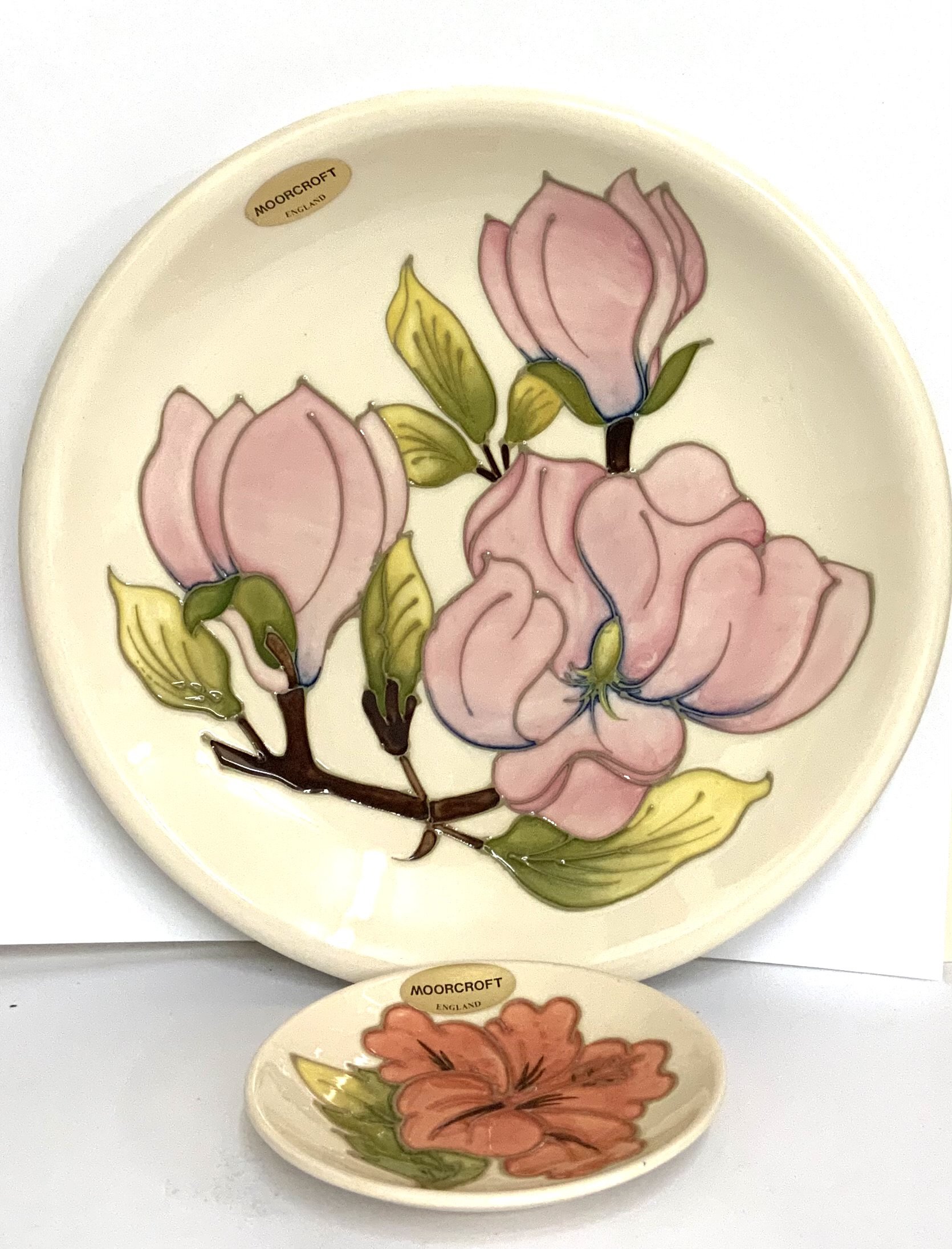 A Moorcroft Magnolia pottery 26cm plate together with a small Moorcroft dish 11.5cm